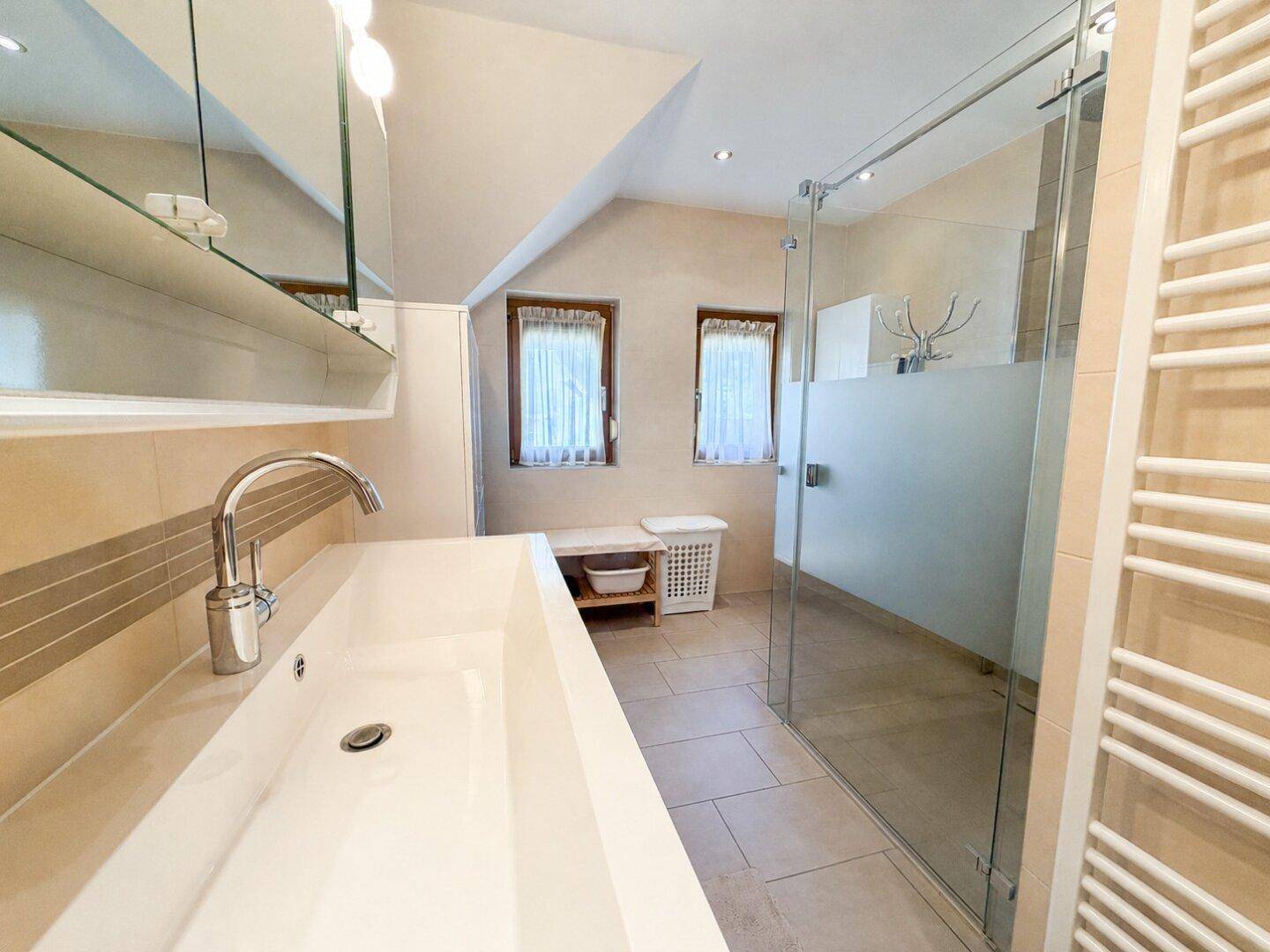 Modernes Badezimmer mit großer begehbarer Dusche, Einzelwaschbecken und Dachschrägen.