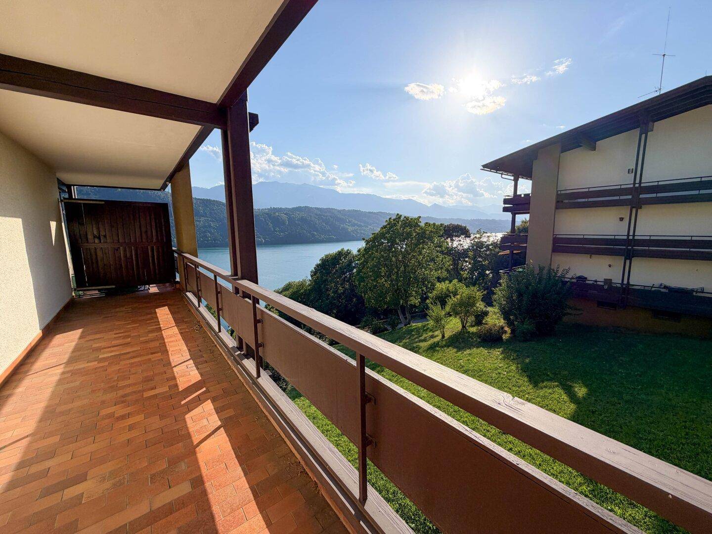 Großer Balkon mit Seeblick und Bergszenerie, ideal für entspannte Stunden im Freien.