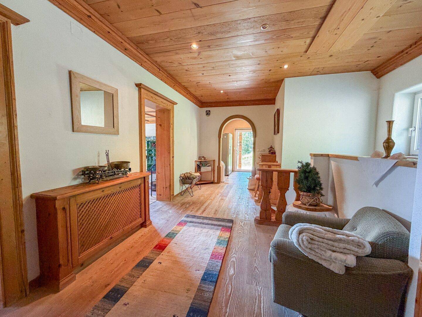 Heller Flur mit Holzboden, Holzdecke und traditionellen Holzelementen, die eine warme Atmosphäre schaffen.