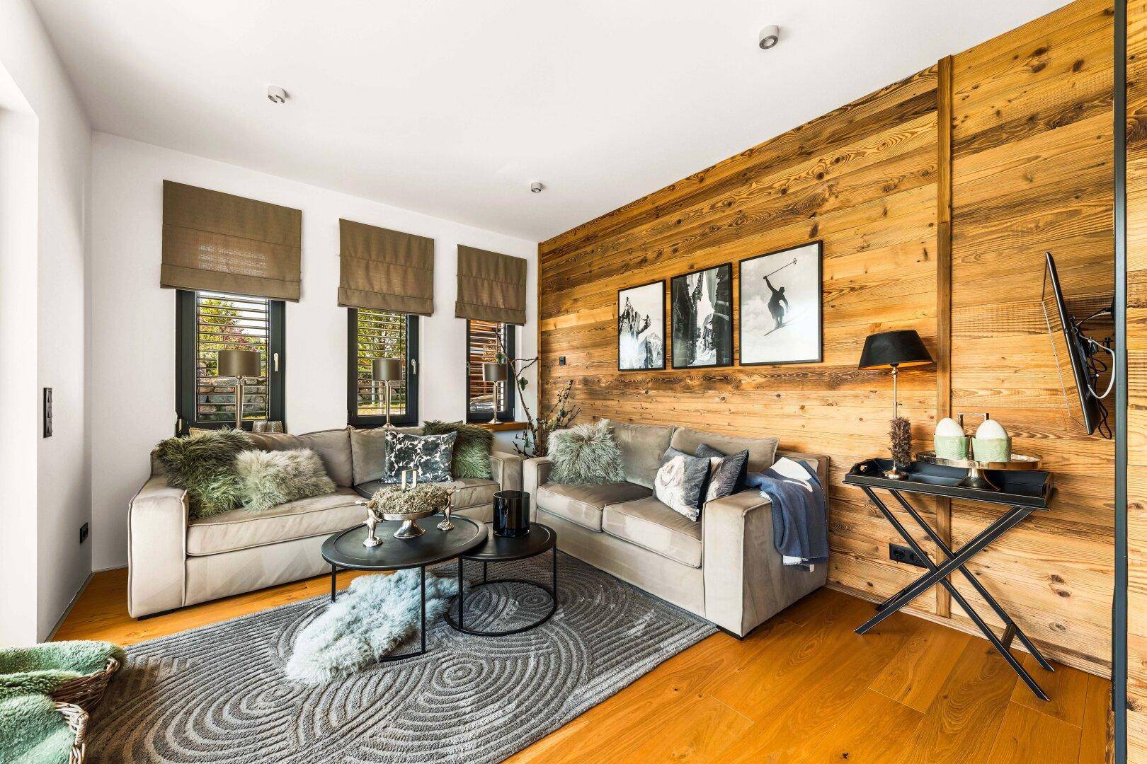 Komfortabler Wohnbereich mit weichen Sofas, Holzwänden und stilvoller Dekoration.