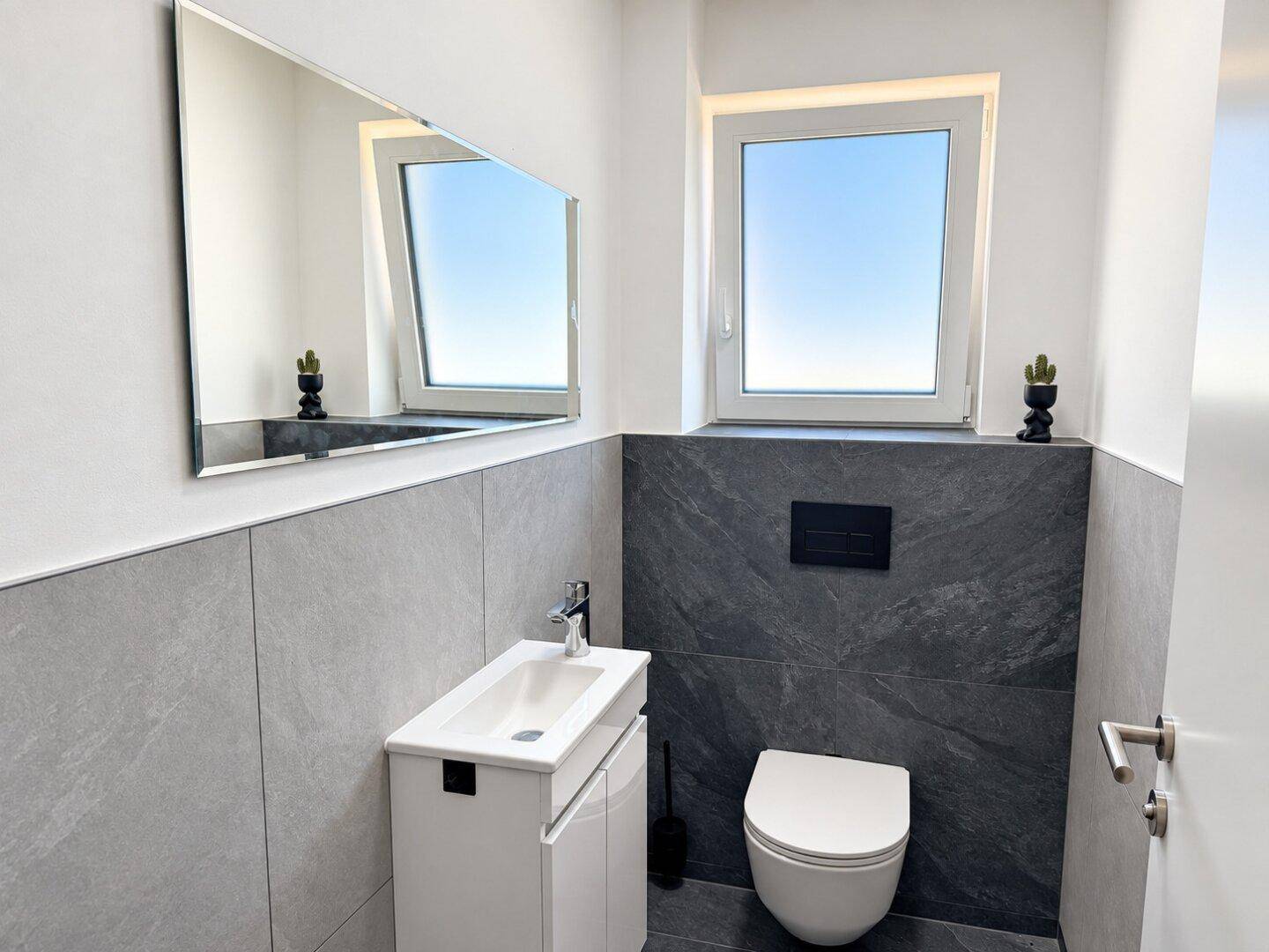Modernes Gäste-WC mit Wand-WC, Einzelwaschbecken und Fenster.