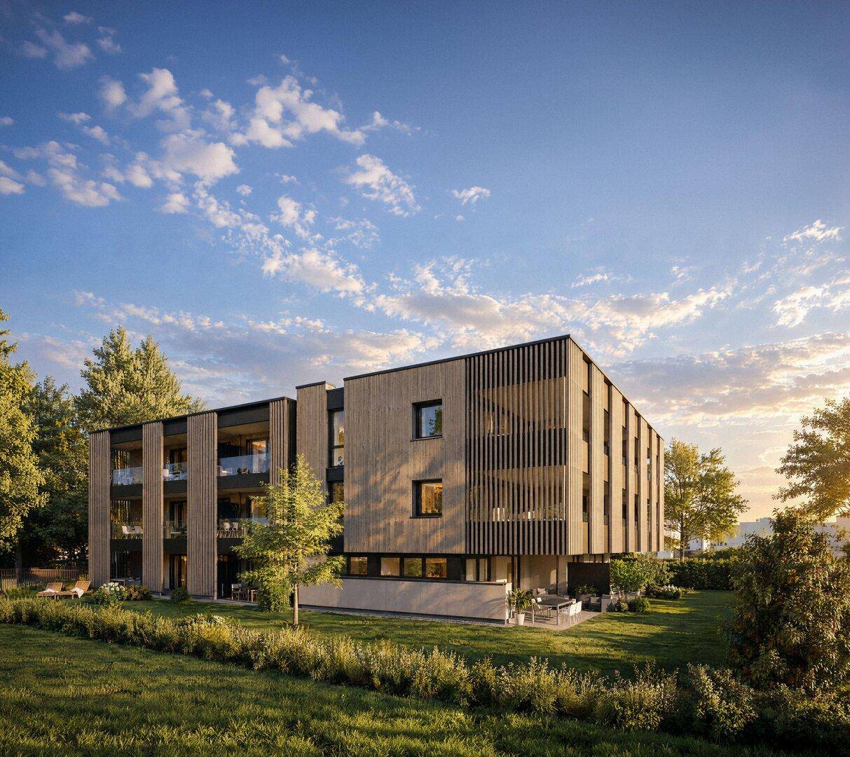 Modernes Wohngebäude mit Holzverkleidung und großen Balkonen, eingebettet in eine grüne Landschaft.