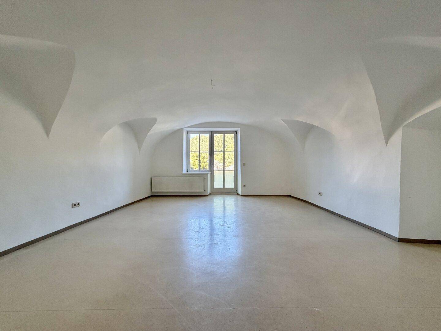 Geräumiger Raum mit eleganter Gewölbedecke und hellem Boden, ideal für vielseitige Nutzung.