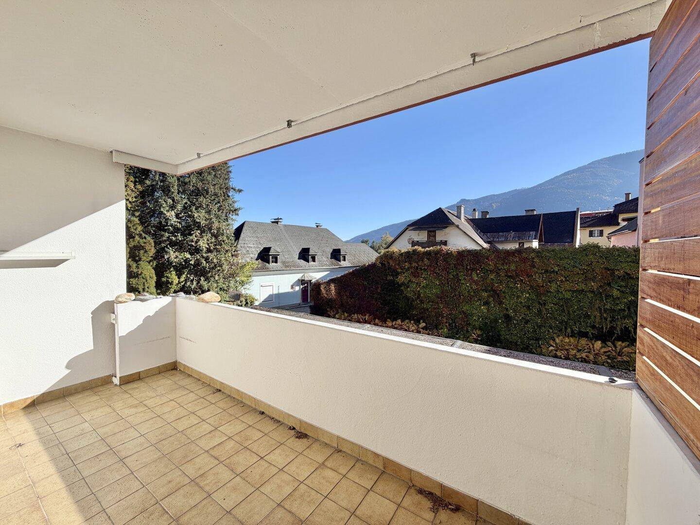 Geräumiger Balkon mit Fliesenboden und Blick auf die umliegende Berglandschaft.