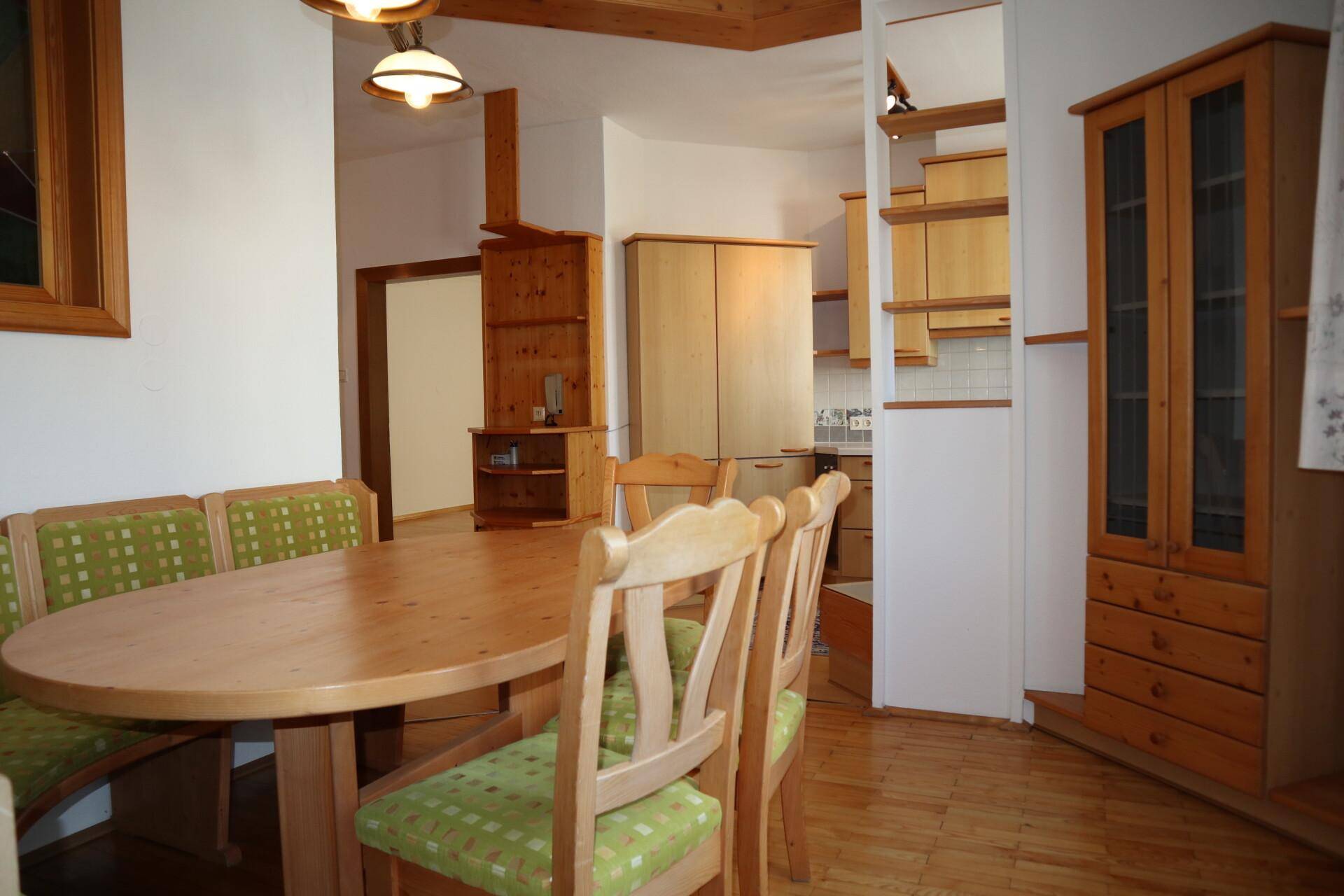 Gemütlicher Essbereich mit Holztisch und Sitzbank, offen zur Küche hin.