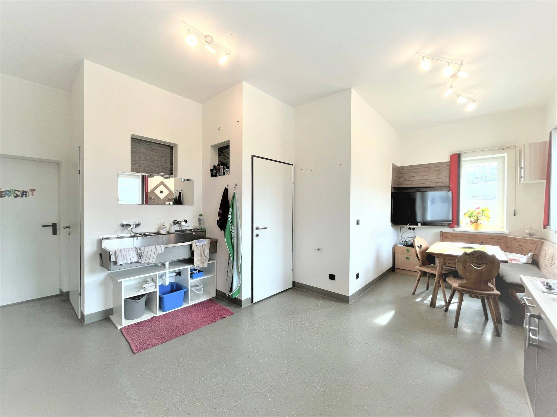 Kombinierter Küchen- und Essbereich mit Holztisch, Eckbank und einer kleinen Spüle, ideal für Pausen.