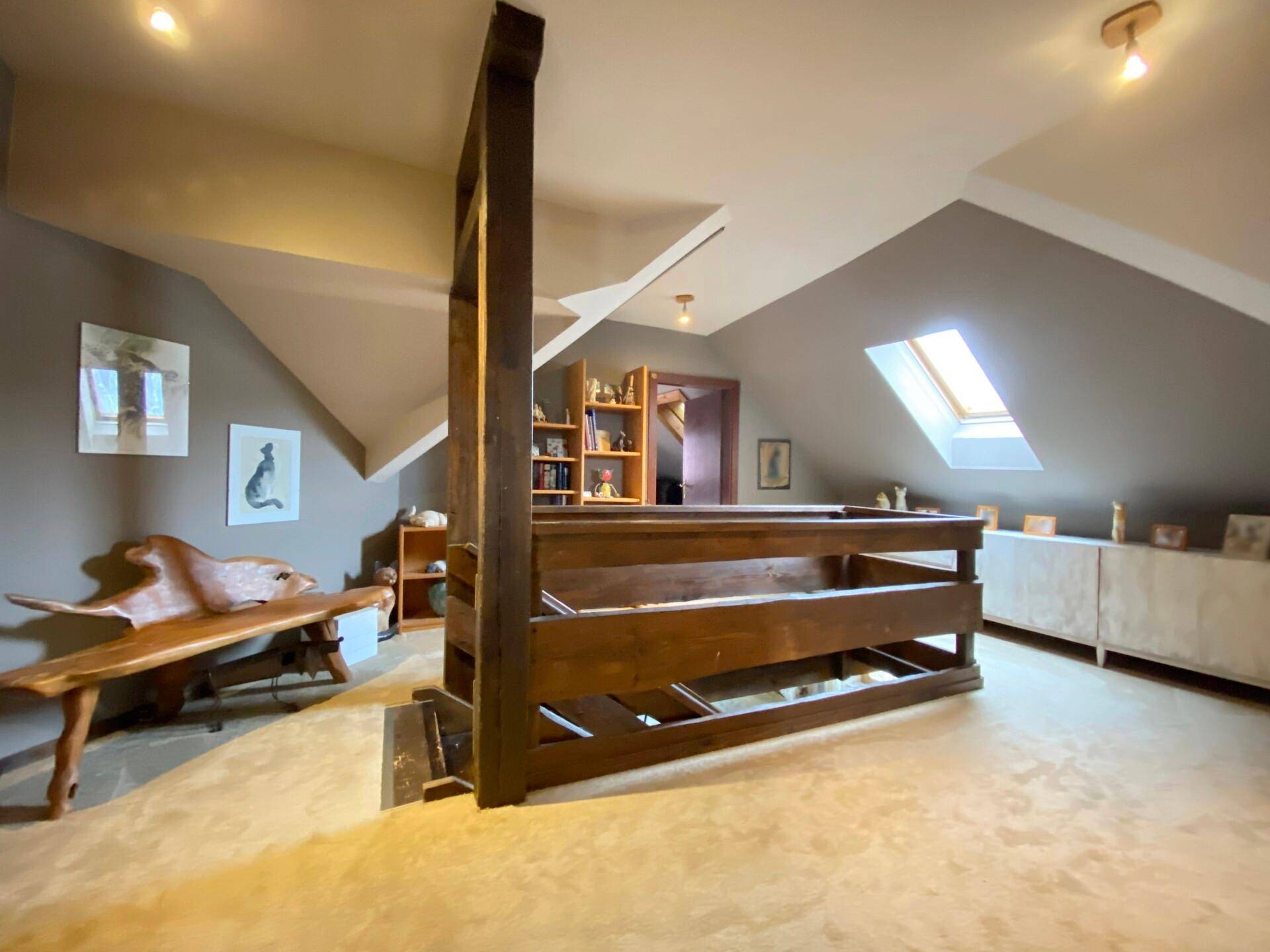 Heller Dachbodenbereich mit Dachschrägen, Teppichboden und Holzelementen.