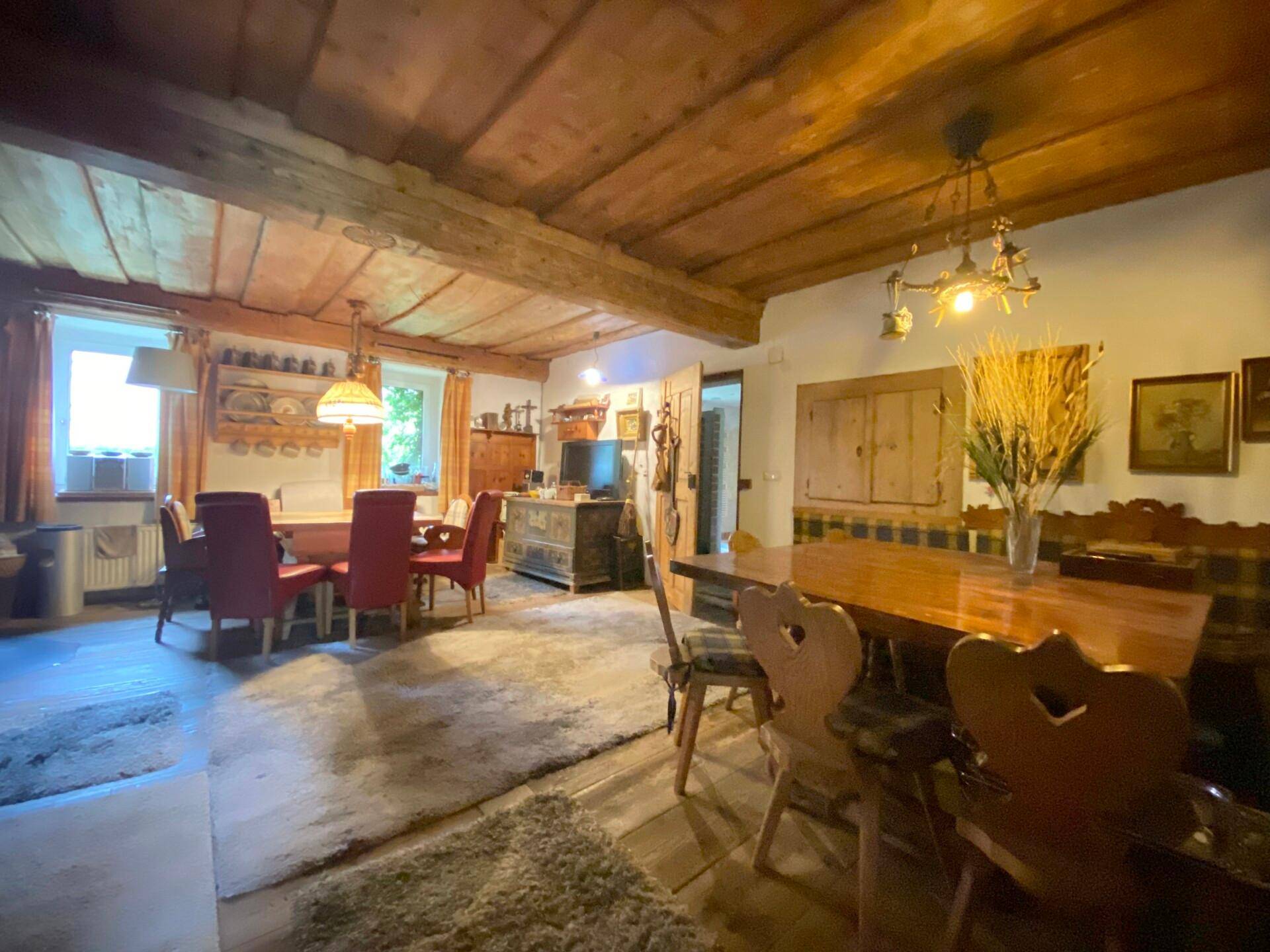Großer Essbereich mit traditionellen Holzmöbeln, Holzbalkendecke und Teppich.