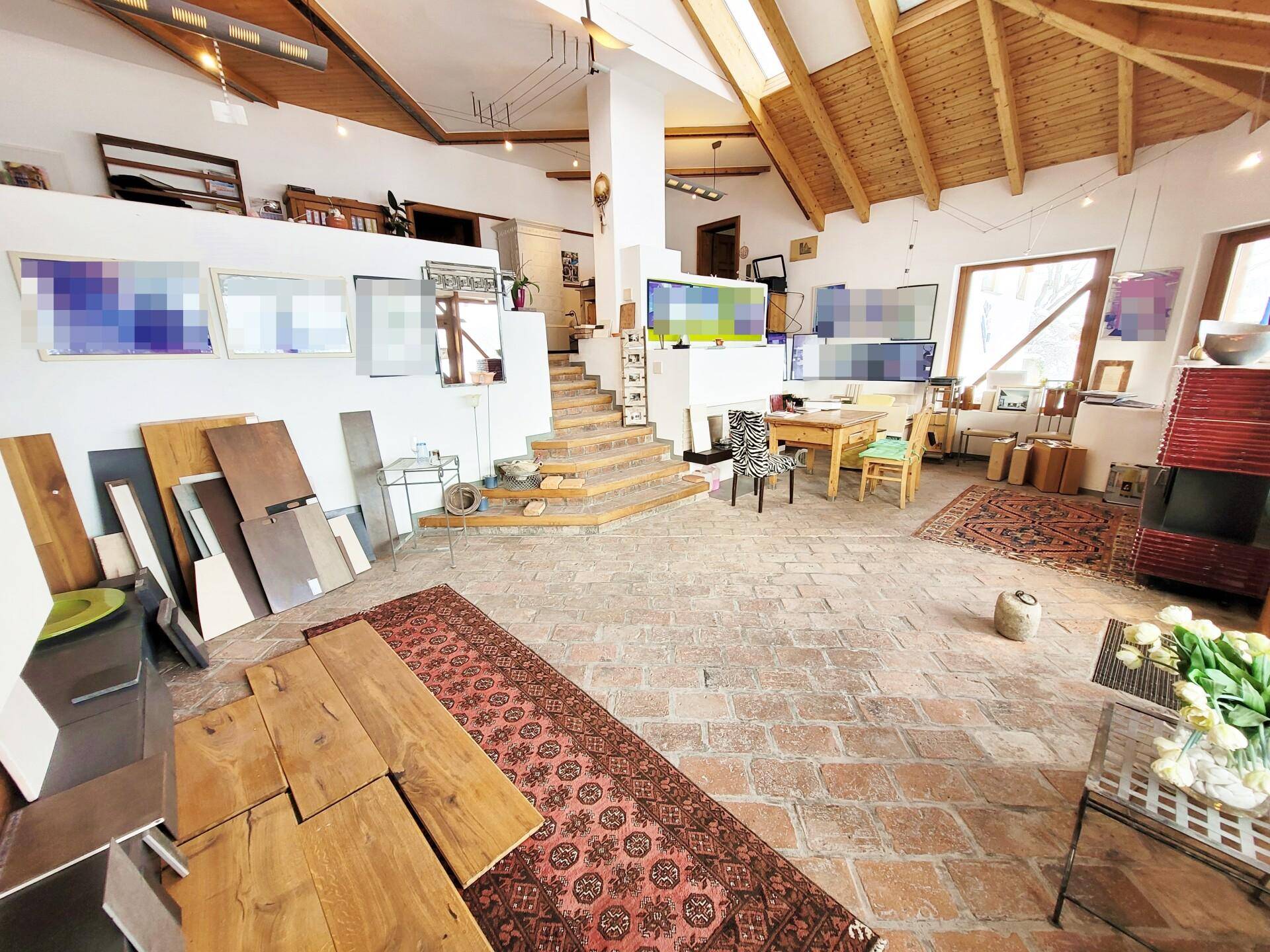 Großer offener Arbeitsbereich mit hohen Decken, Holzbalken und rustikalem Ziegelboden.