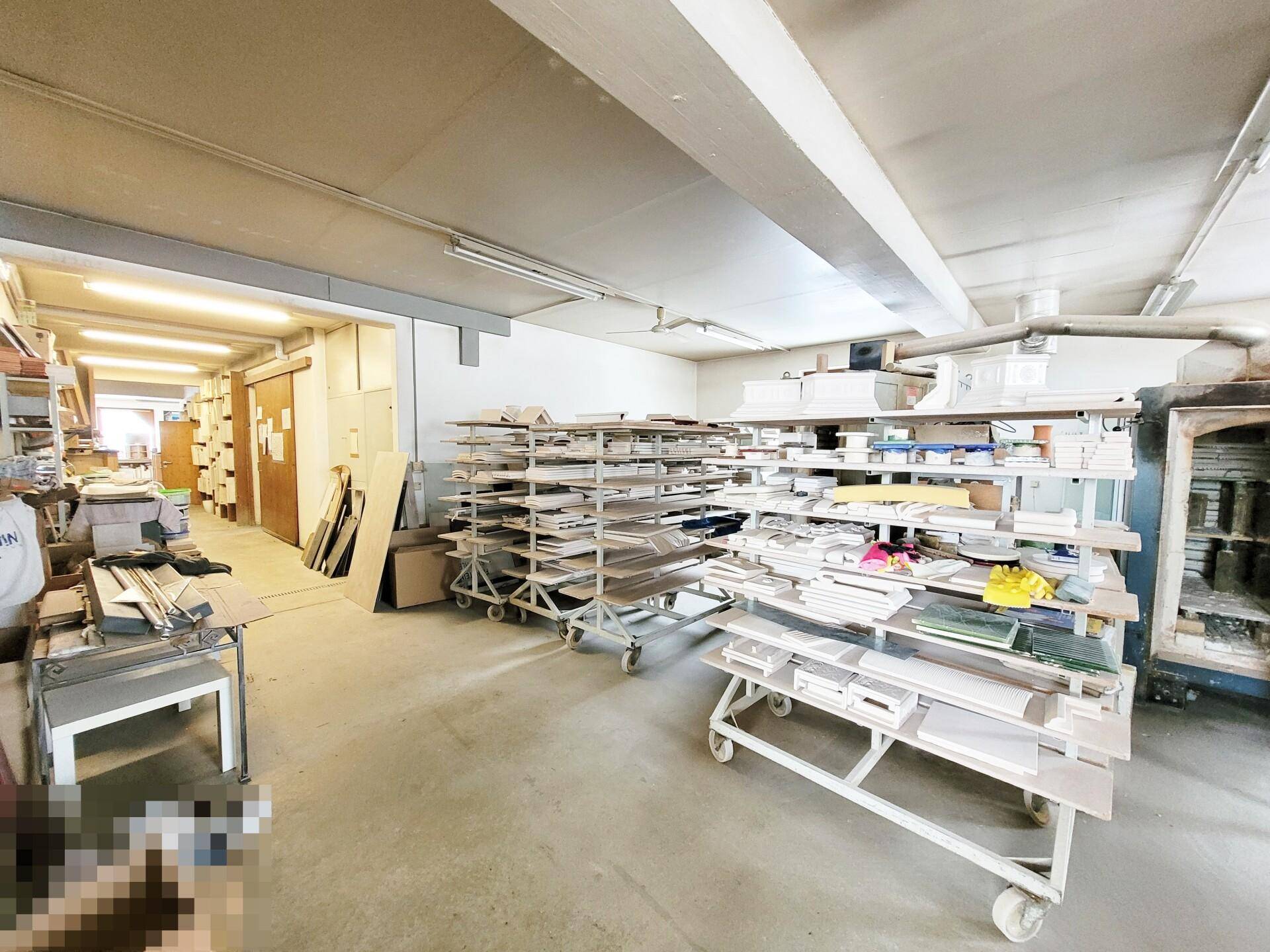 Organisierter Werkstattbereich mit mobilen Regalen und verschiedenen Materialien zur Bearbeitung.