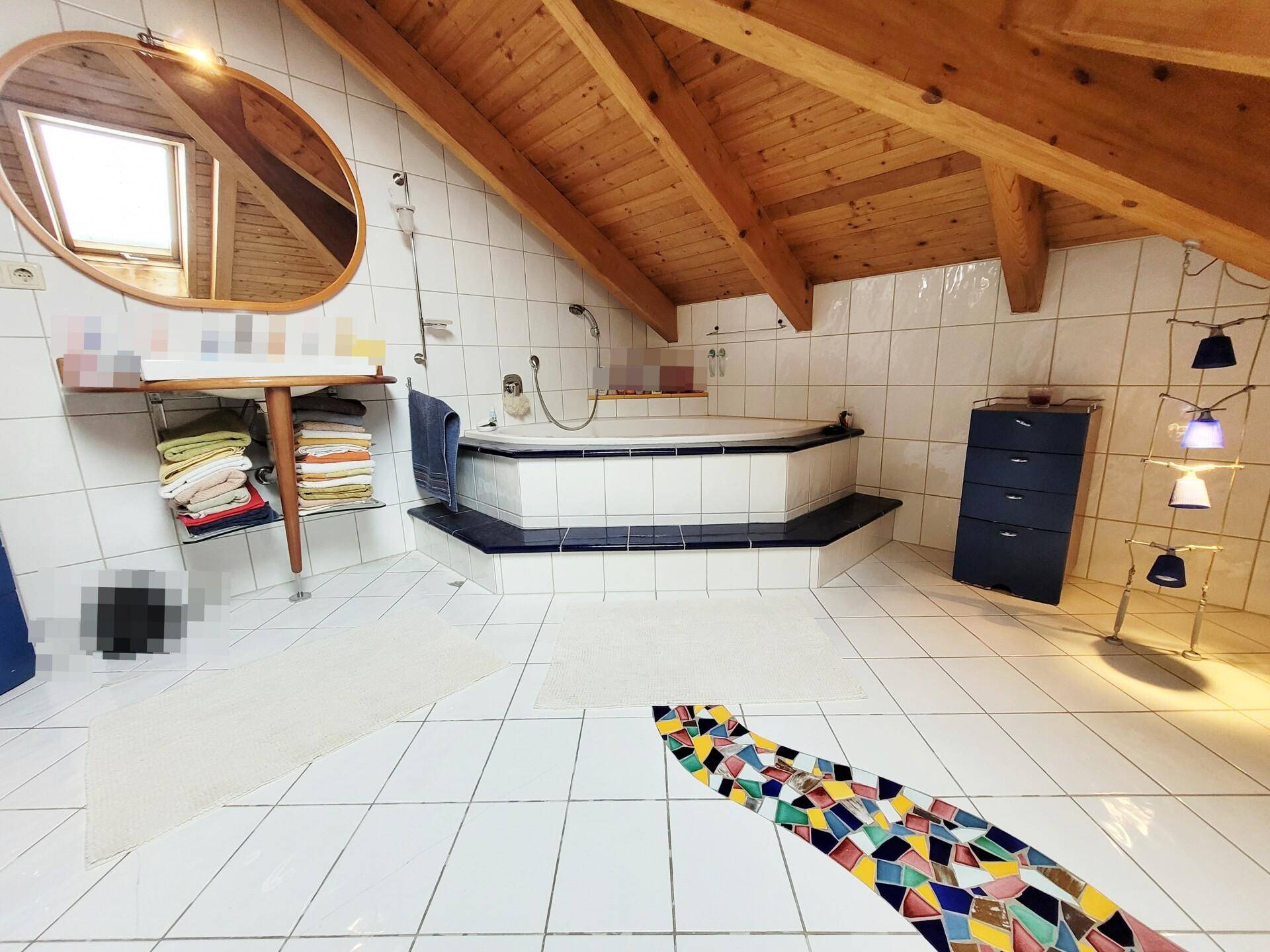 Geräumiges Badezimmer mit Eckbadewanne, weißen Fliesen und Holzdachschräge.