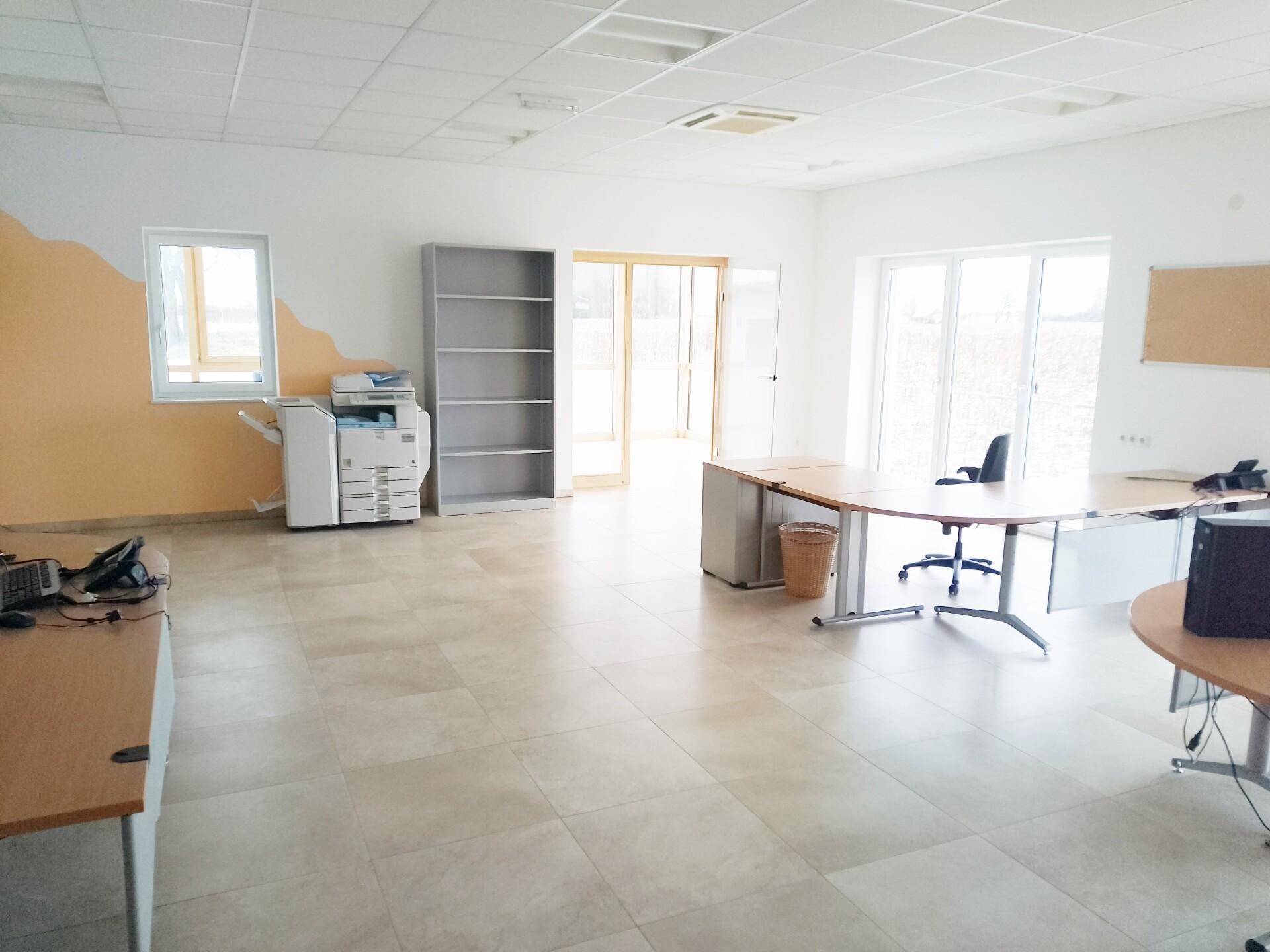 Großes, helles Büro mit Fliesenboden, mehreren Arbeitsplätzen und einem Kopiergerät.