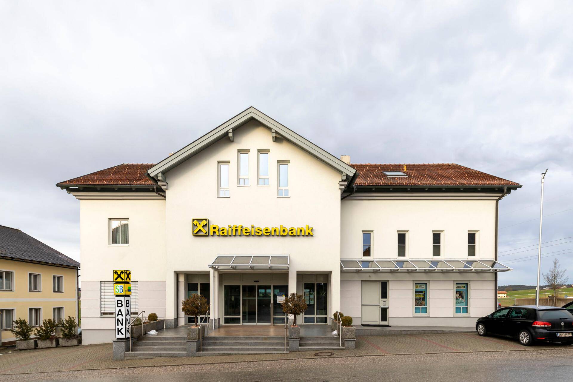 Traditionelles Bankgebäude der Raiffeisenbank mit klassischer Architektur und Vordach.