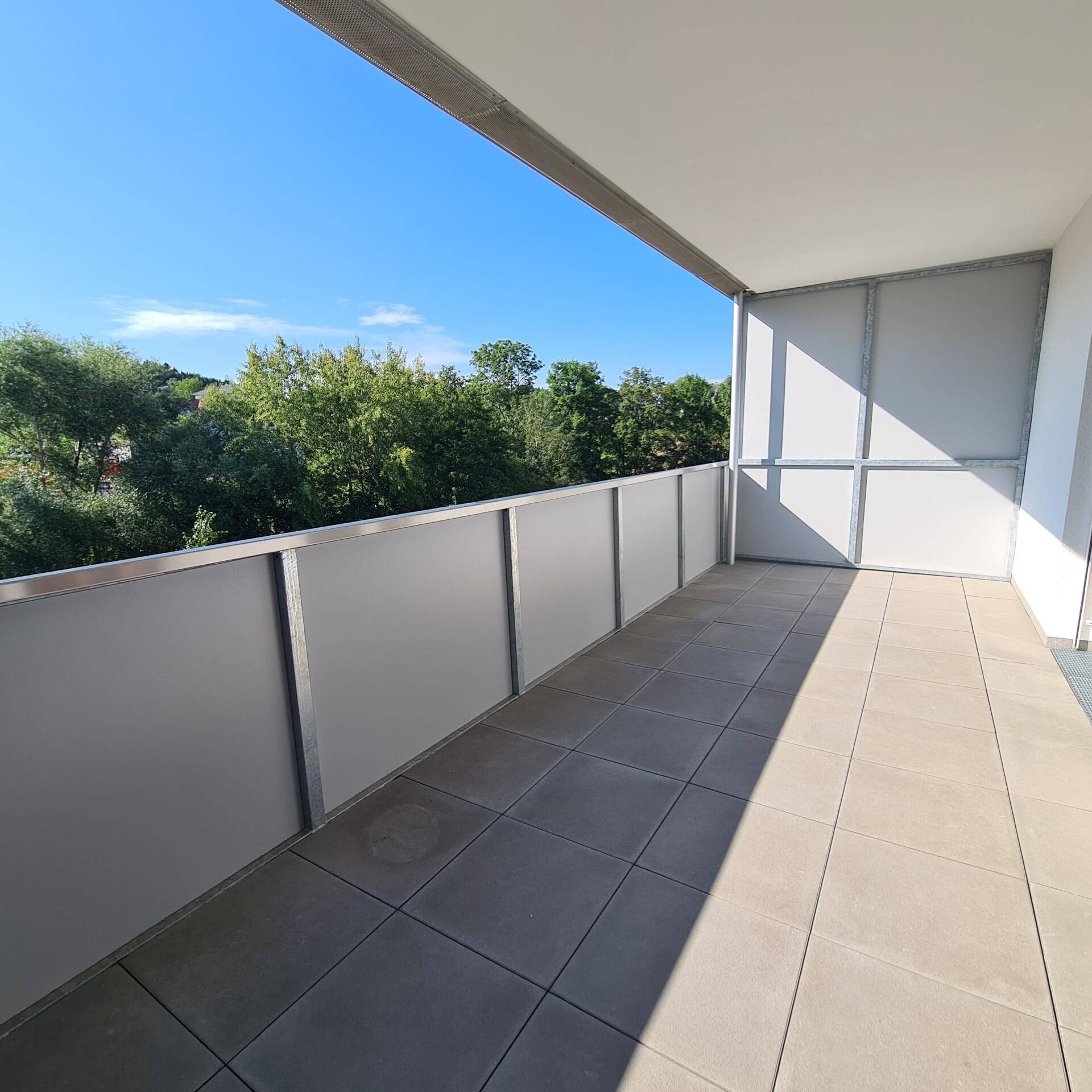 Geräumiger Balkon mit Fliesenboden und Blick ins Grüne, ideal zum Entspannen.