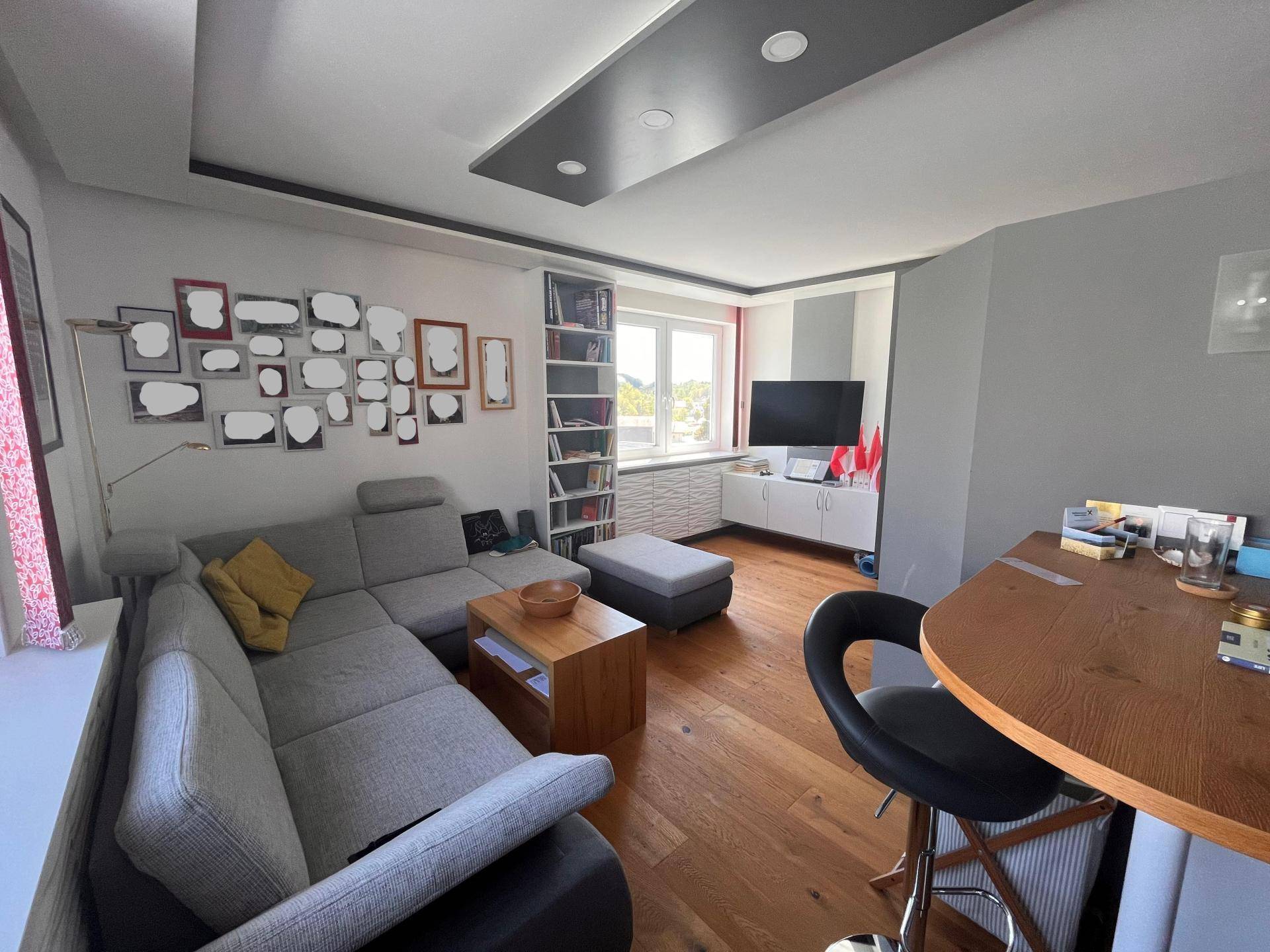 Modernes Wohnzimmer mit L-förmigem Sofa, Holzboden und einer Bar-Theke.