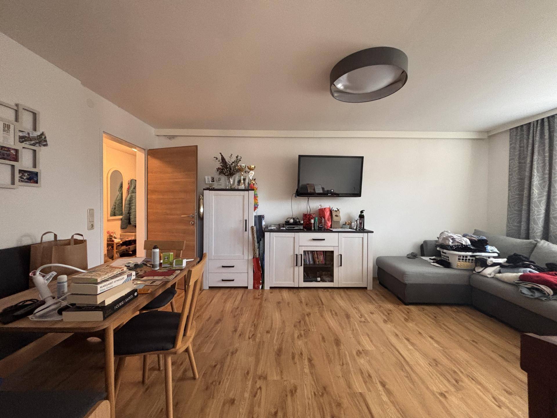 Kombinierter Wohn- und Essbereich mit Holzboden, Esstisch und Sofa.