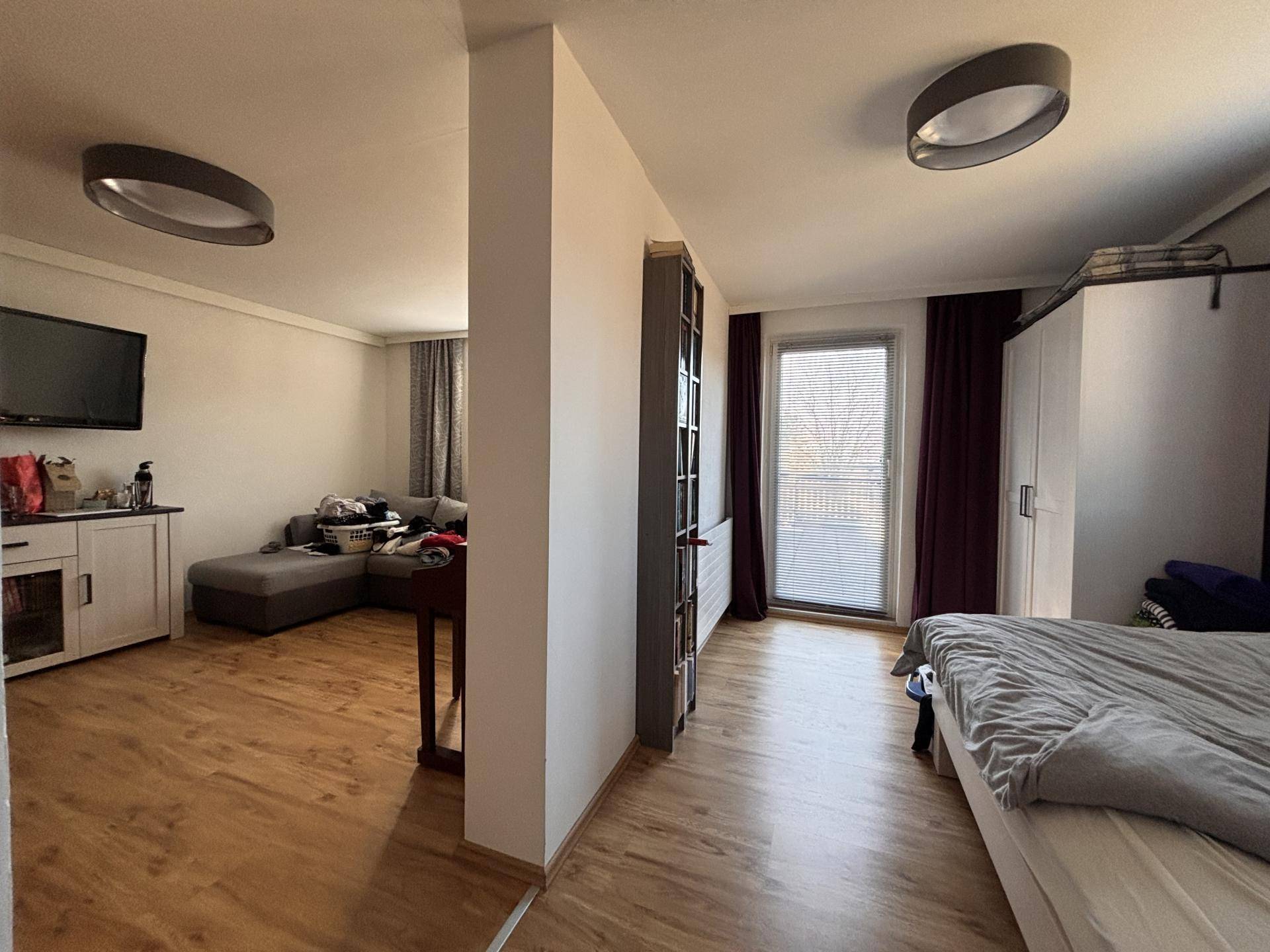 Schlafzimmer mit Zugang zu einem Balkon und angrenzendem Wohnbereich.