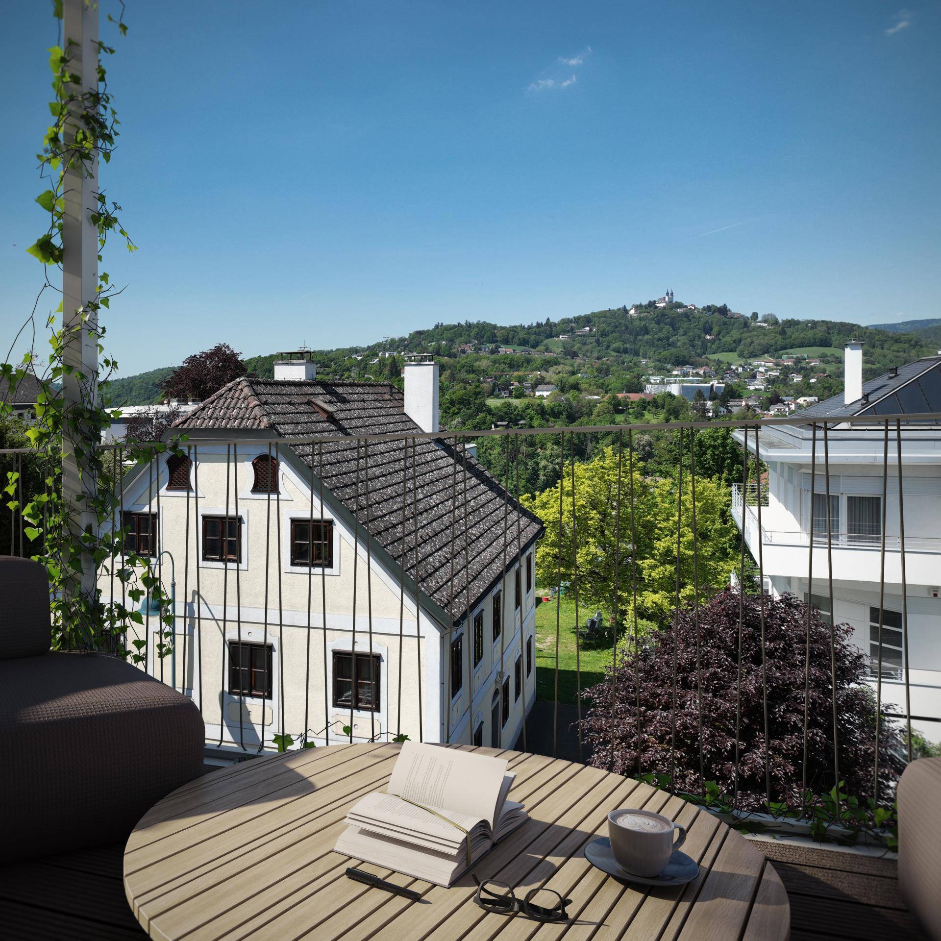 Gemütlicher Balkon mit Sitzgelegenheiten und weitem Blick über die Landschaft und alte Gebäude.