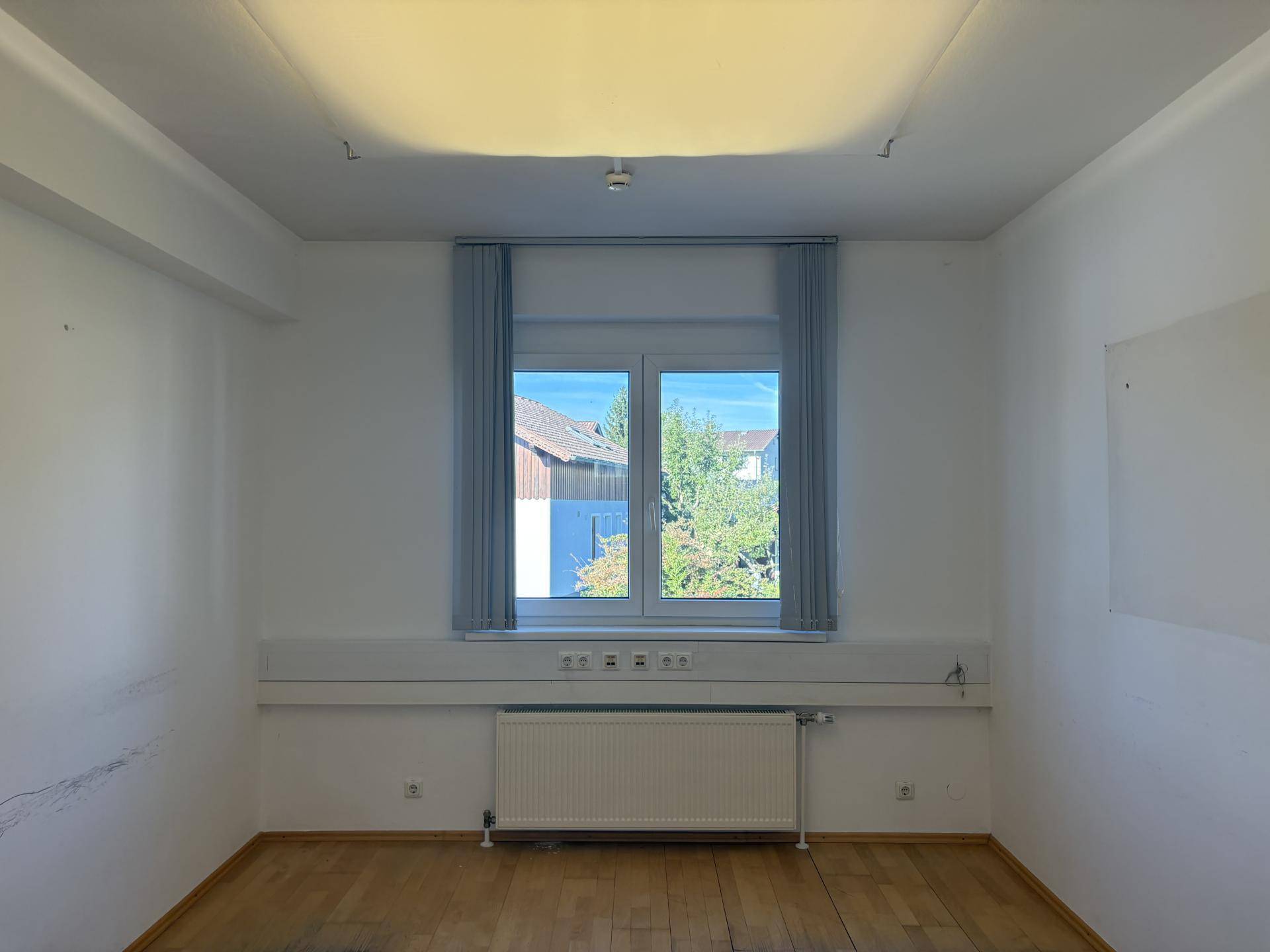 Kleiner, heller Büroraum mit Fenster und Heizkörper, ideal für ein Einzelbüro oder Besprechungen.