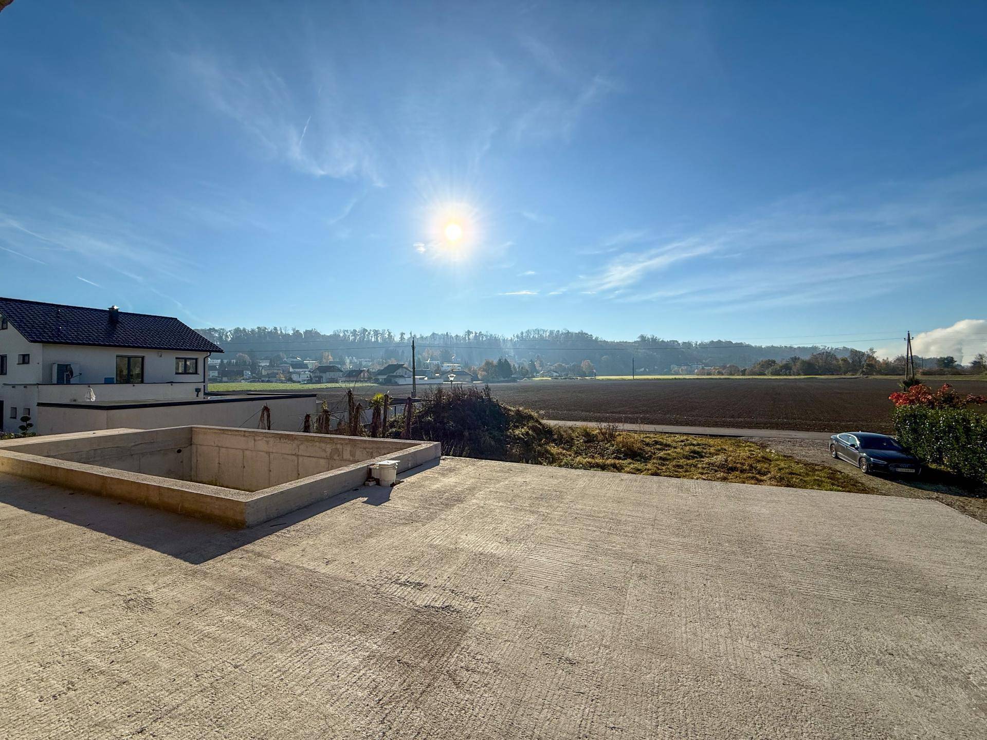 Große Betonfläche im Außenbereich mit weitem Blick über die sonnige Landschaft.
