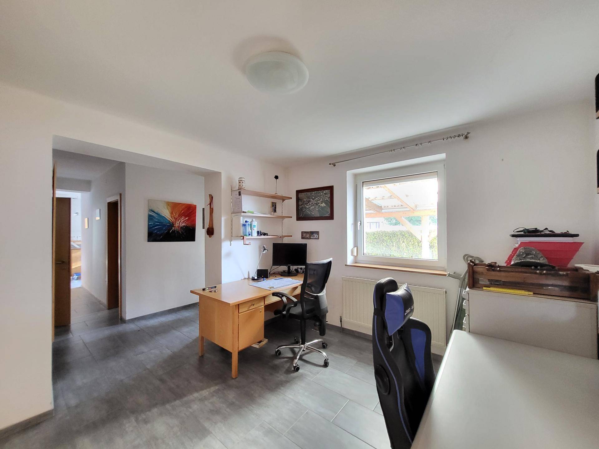Funktionales Arbeitszimmer mit Fenster und Blick ins Grüne, ideal für Home-Office.