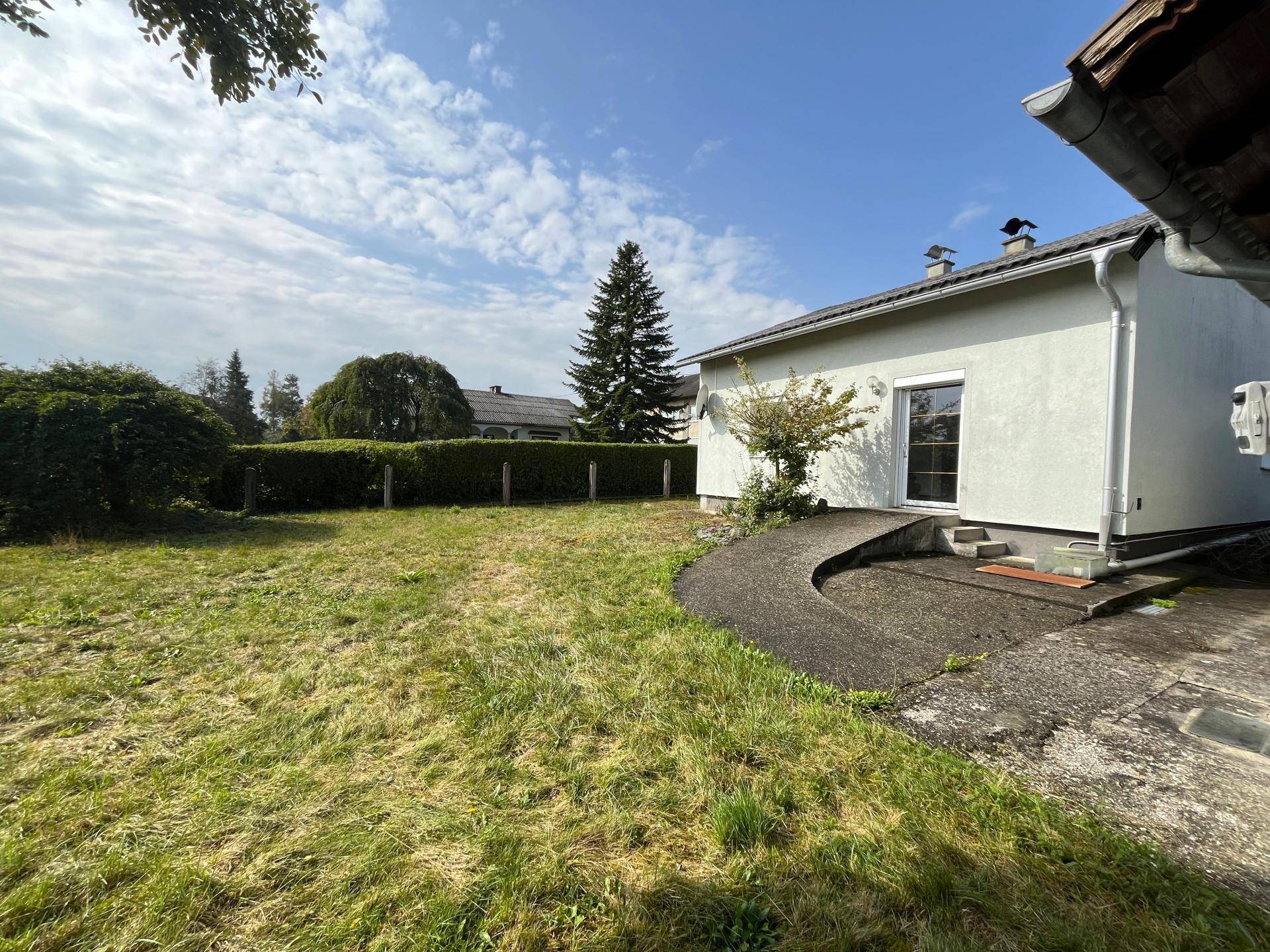 Gepflegter Gartenbereich mit Rasenfläche und Hecke, ideal zum Entspannen.