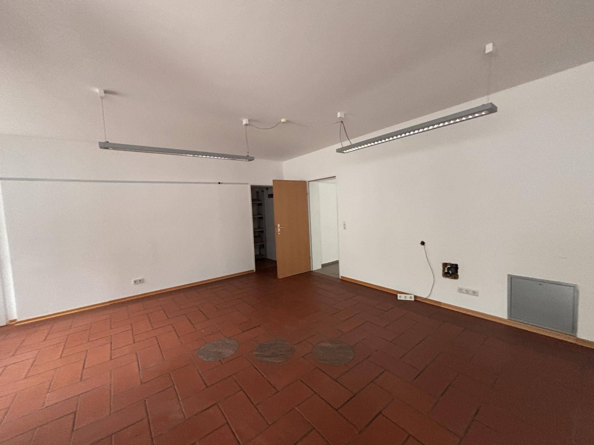 Leerer Raum mit Terrakottafliesen und weißen Wänden, bereit zur individuellen Gestaltung.