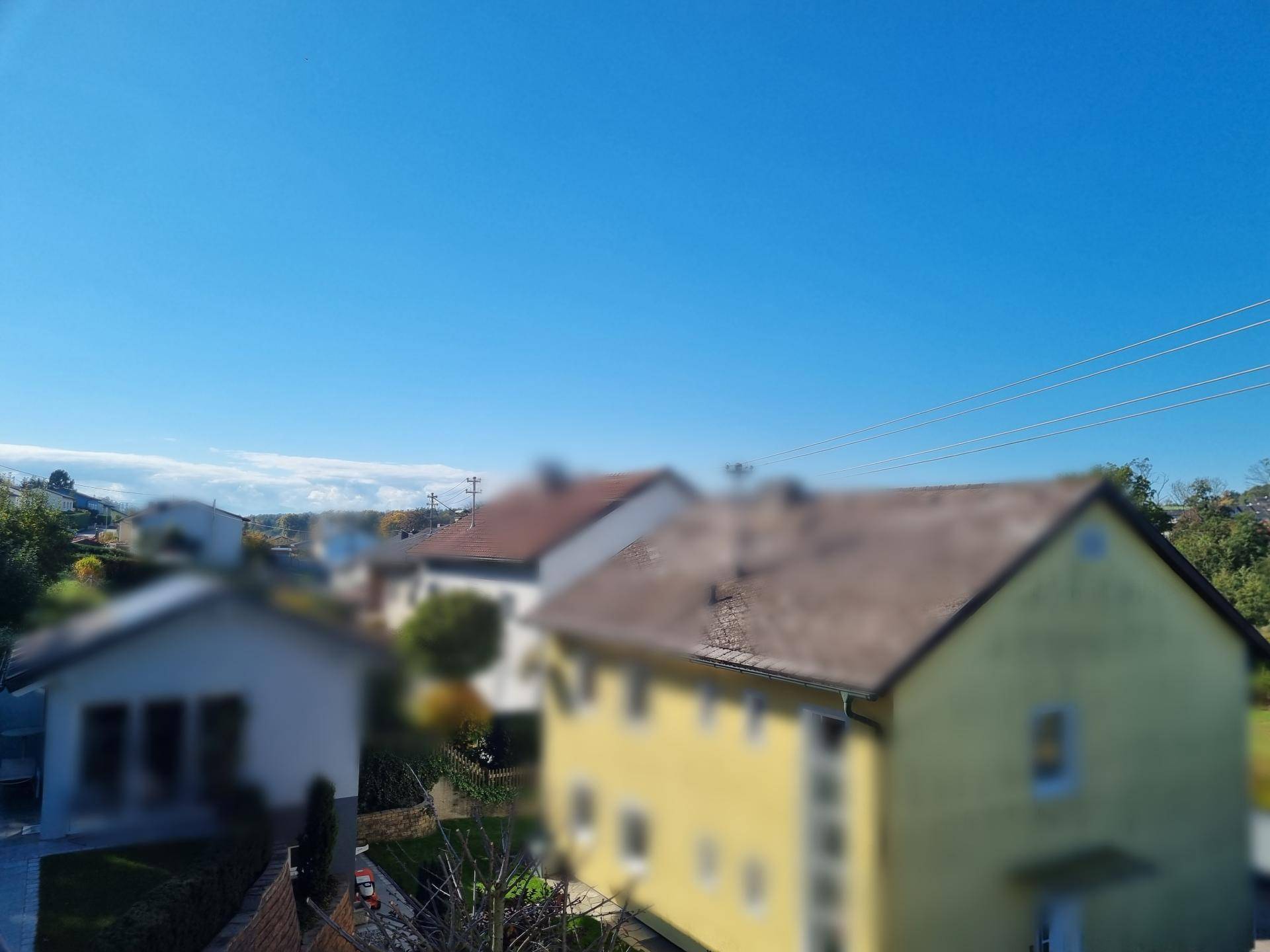 Weitläufiger Blick über die Nachbarschaft mit Wohnhäusern und blauem Himmel an einem sonnigen Tag.