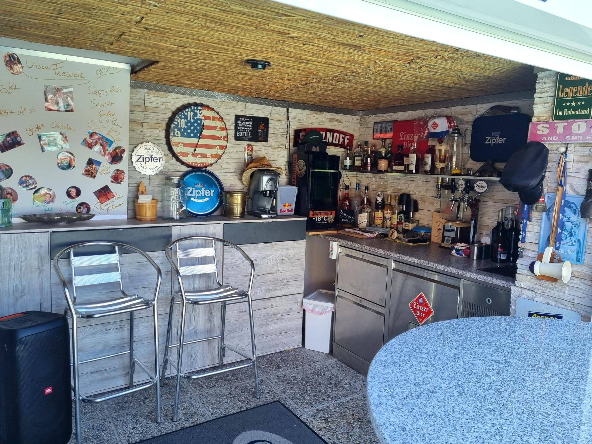 Rustikale Bar mit Theke, Hockern und Regalen für Getränke, ideal für gesellige Abende und Unterhaltung.