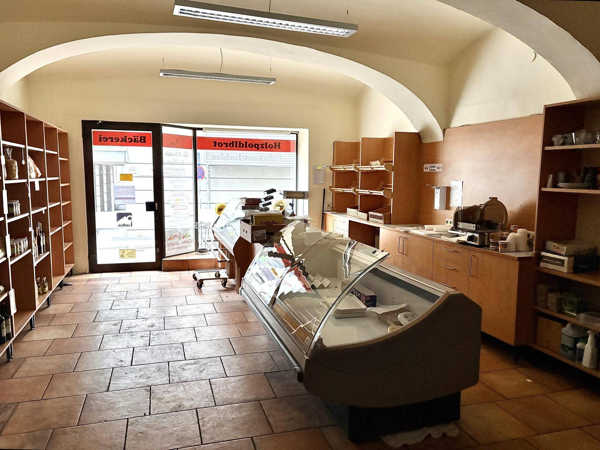 Blick durch das Ladengeschäft mit Theke, Auslage und dem Eingangsbereich.