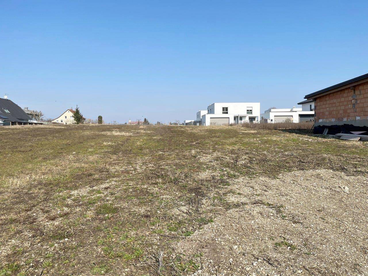 Weitläufiges Baugrundstück mit Blick auf die umliegende Bebauung und offene Landschaft.
