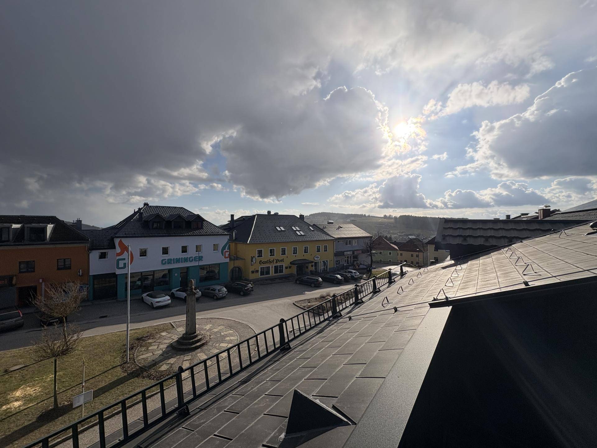 Weitläufiger Blick über die Stadt und die umliegende Landschaft unter einem dramatischen Himmel.