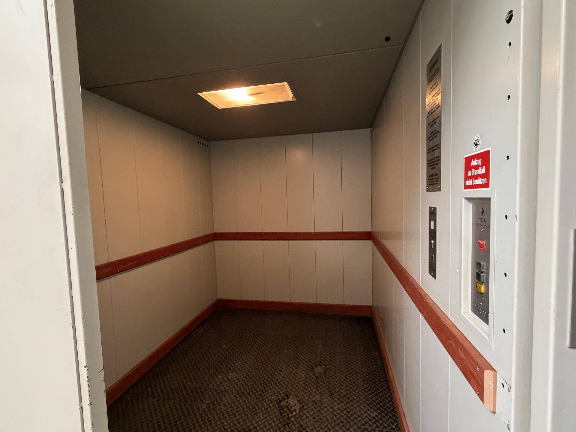 Geräumiger Lastenaufzug mit robustem Boden und Handläufen, geeignet für den Transport schwerer Güter.