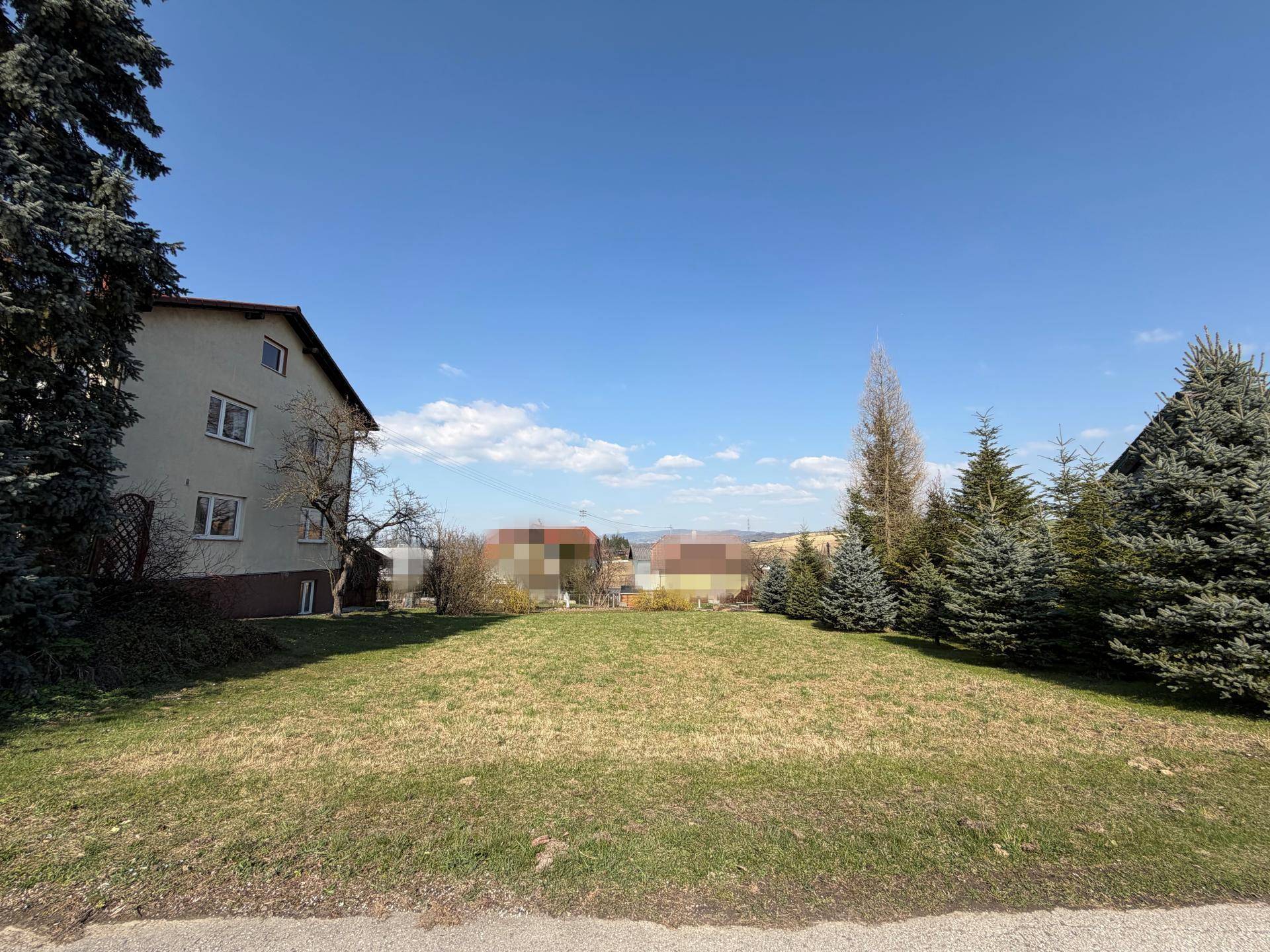Große Rasenfläche neben einem Wohnhaus mit Blick auf die umliegende Landschaft.