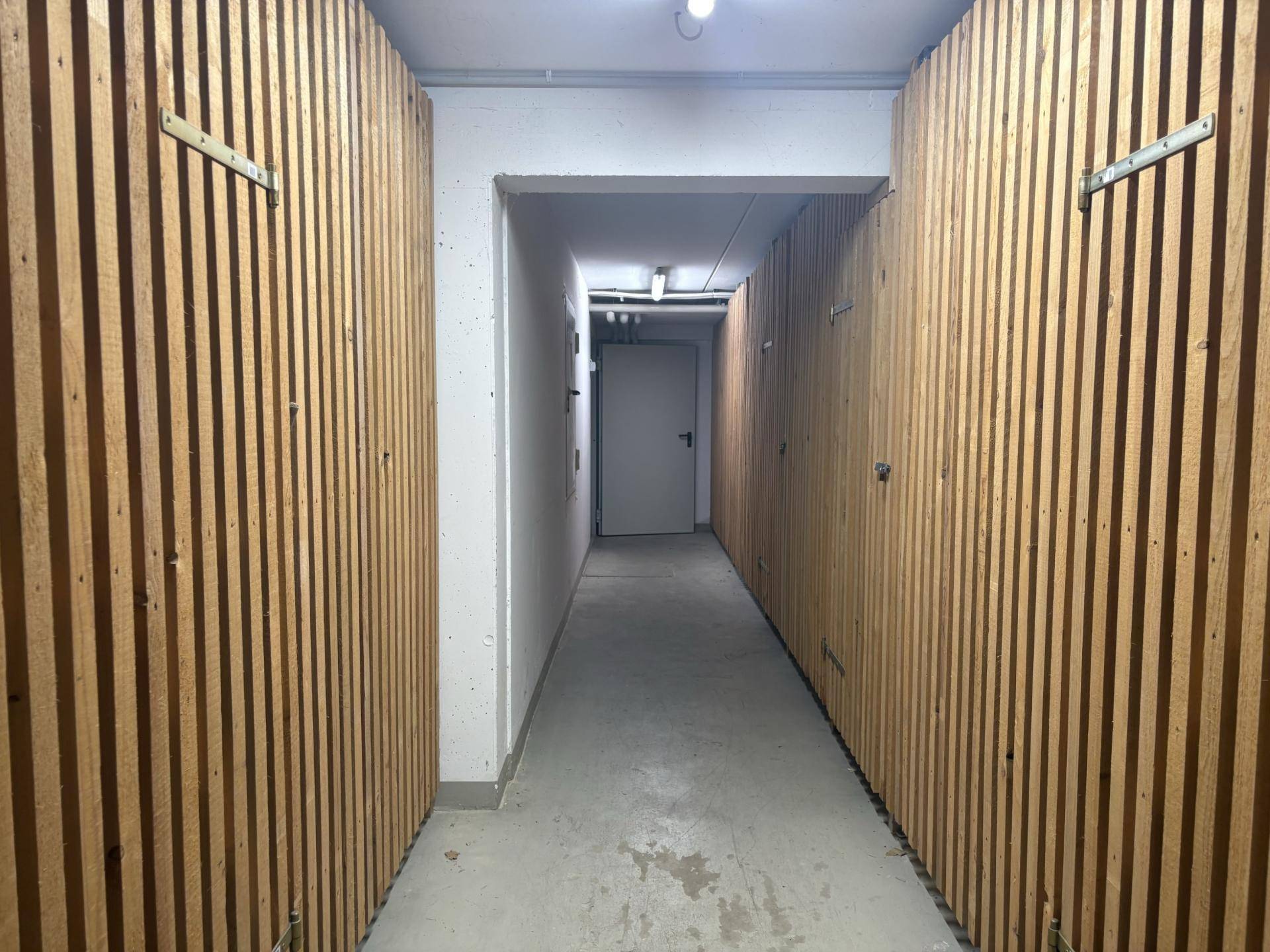 Kellerabteil mit individuellen Holzverschlägen für zusätzlichen Stauraum.