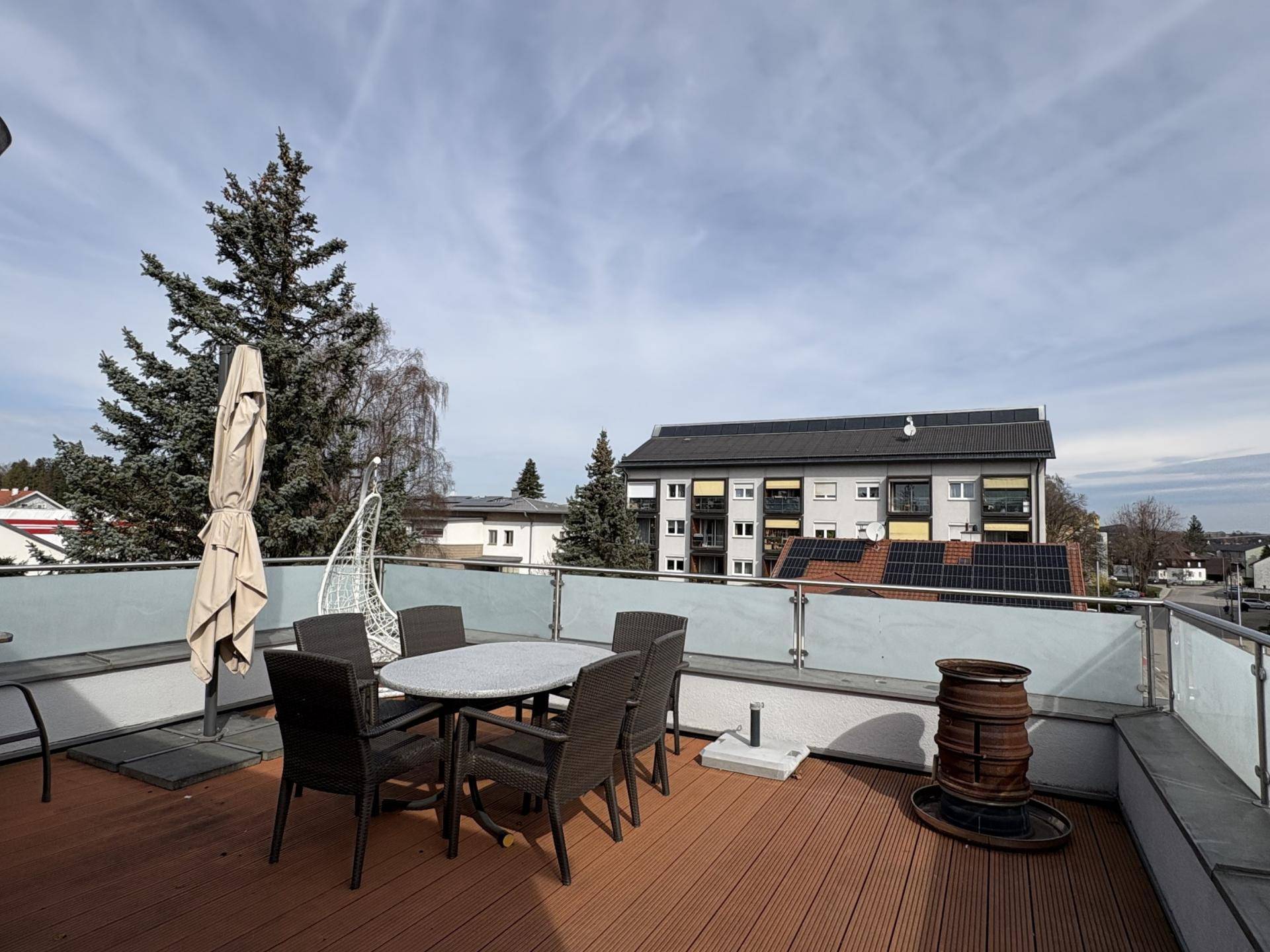 Geräumige Dachterrasse mit Gartenmöbeln und weitem Blick über die Umgebung.