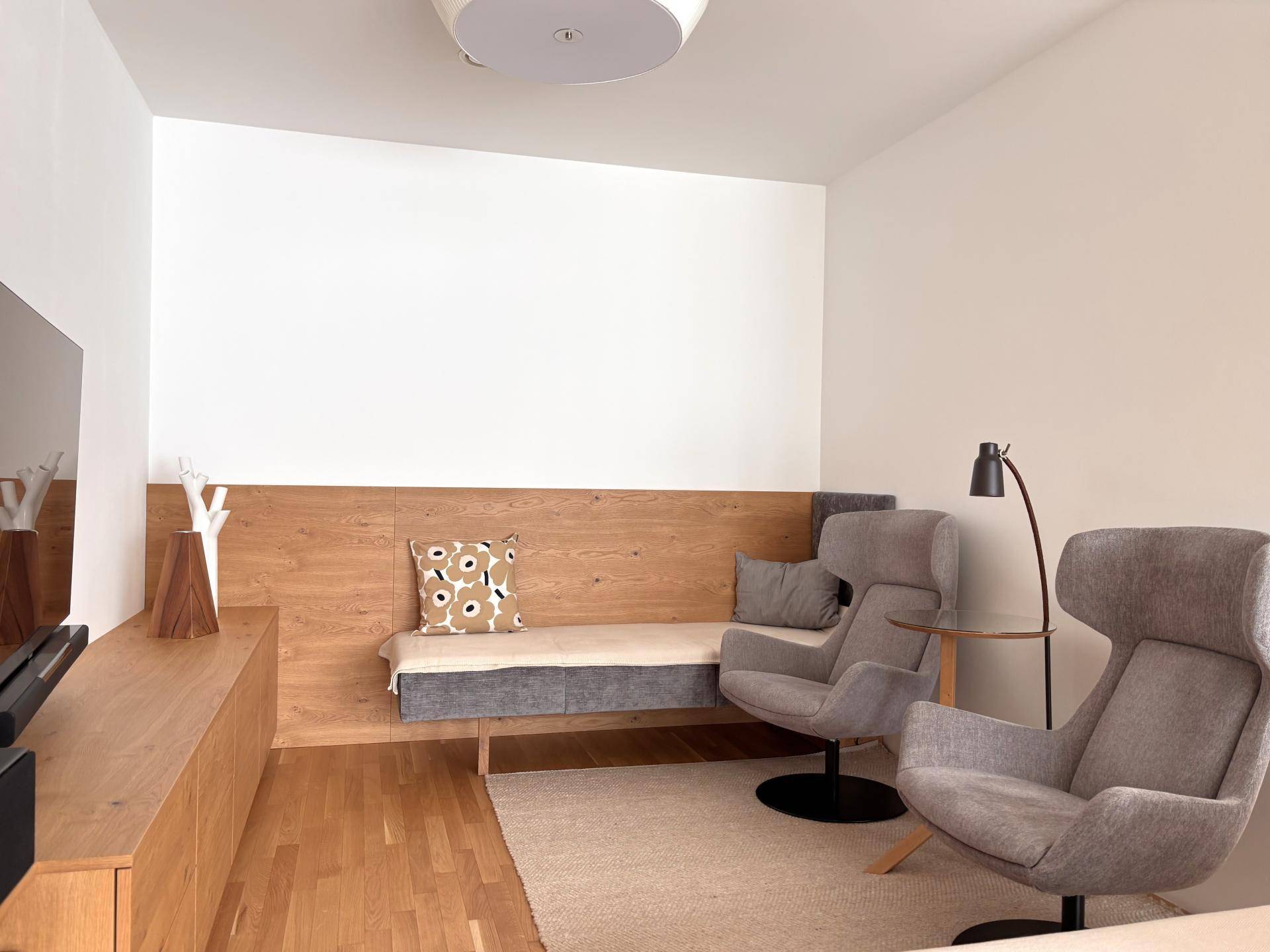 Moderner Wohnbereich mit Holzelementen, bequemer Sitzbank und Fernseher.