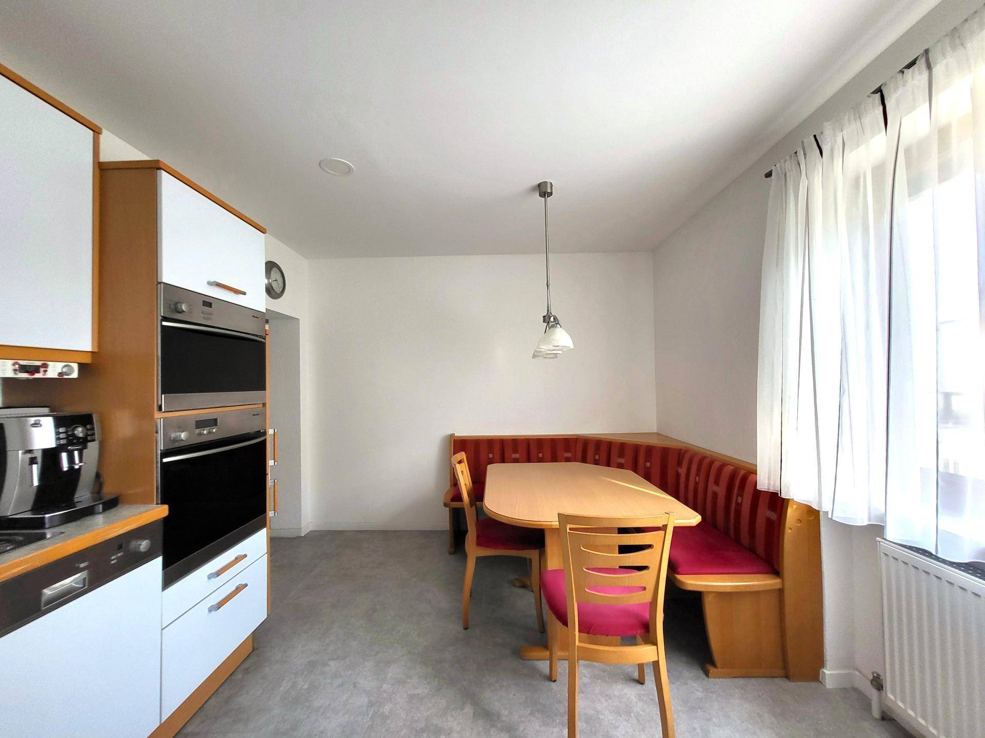 Gemütliche Küche mit Essbereich, Eckbank und Fenster für natürliches Licht.