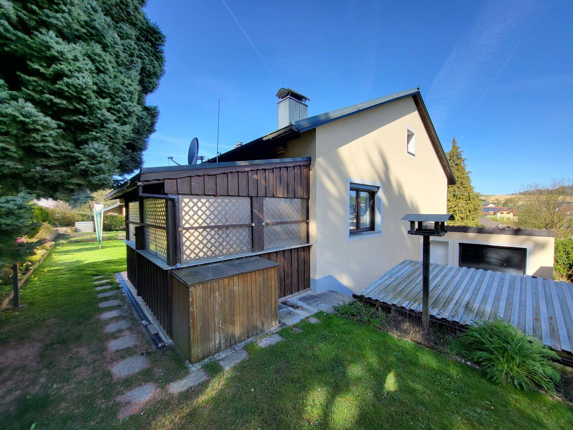 Seitenansicht des Hauses mit Garten, Terrasse und Blick auf die Umgebung.