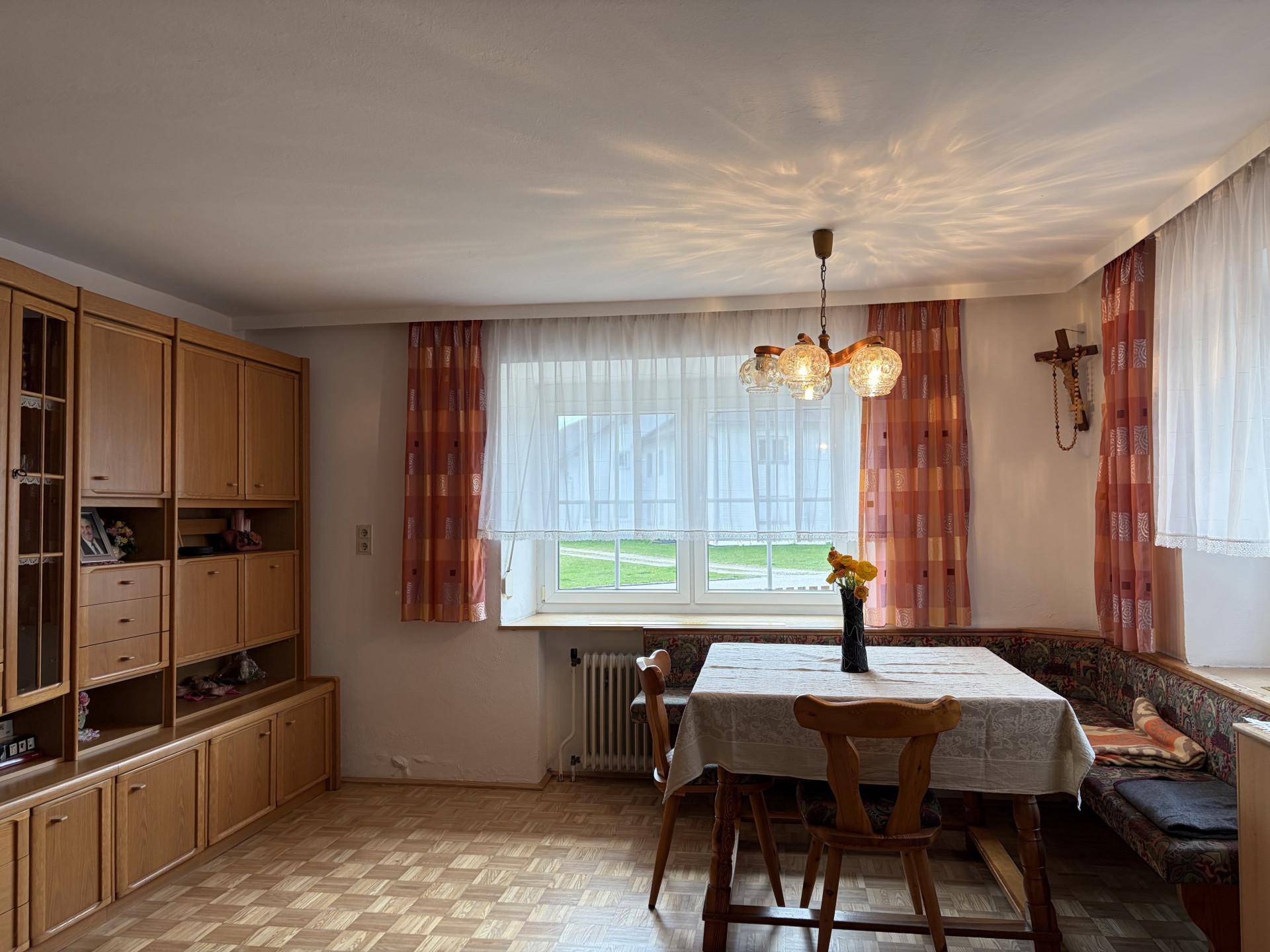 Traditioneller Essbereich mit Holzeinbauschrank, Eckbank und Fenster mit Blick ins Grüne.