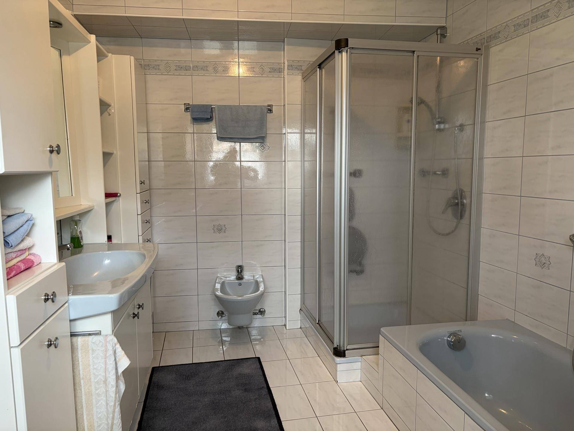 Badezimmer mit Badewanne, Duschkabine, Bidet und Doppelwaschbecken.