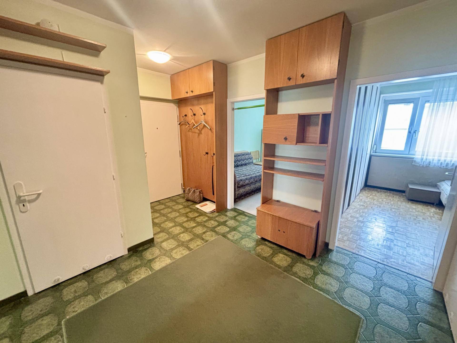 Eingangsbereich mit Einbauschränken und Garderobe, der zu verschiedenen Zimmern führt.