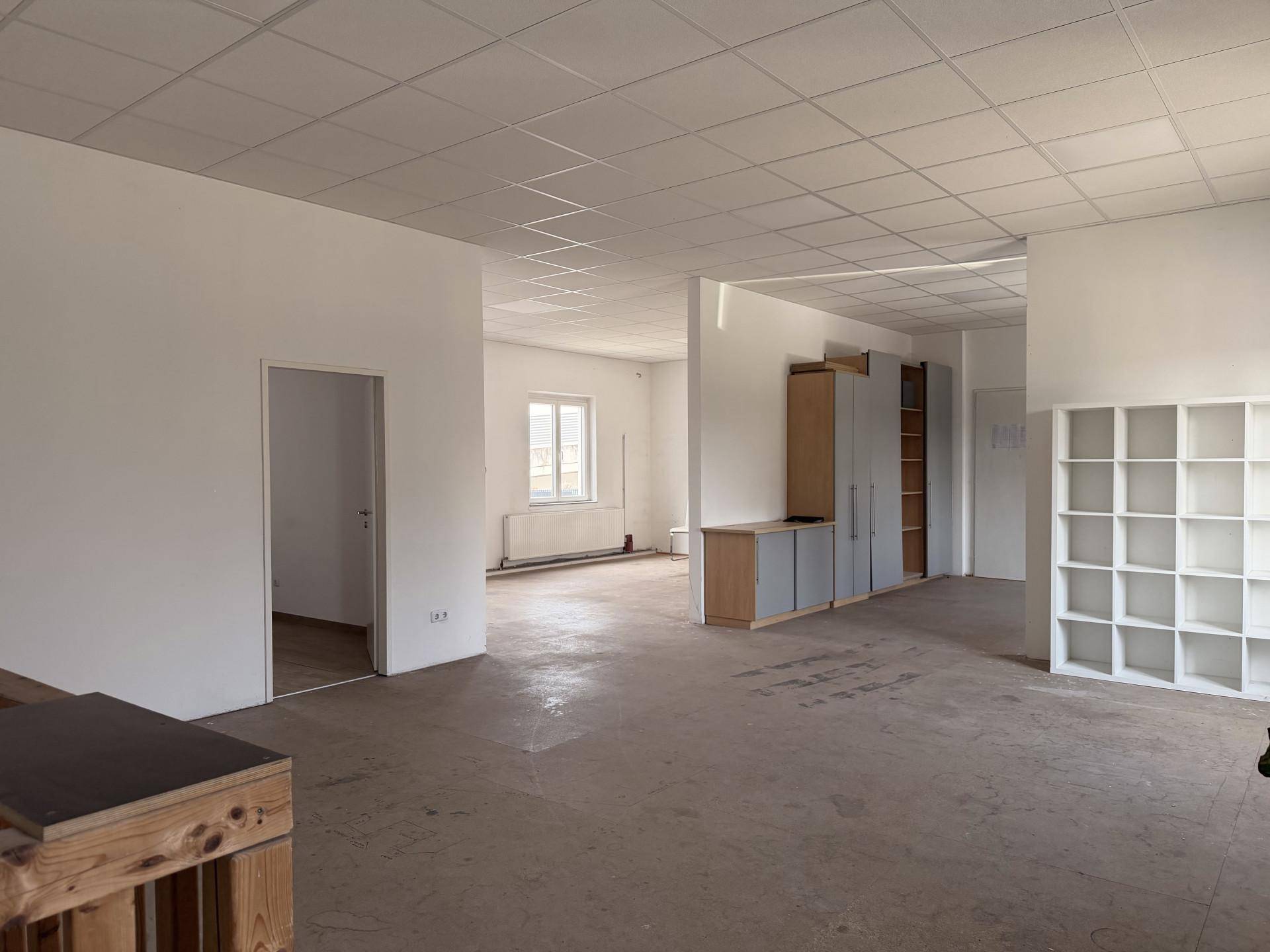 Großer, heller Gewerberaum mit abgehängter Decke und praktischen Einbauschränken.