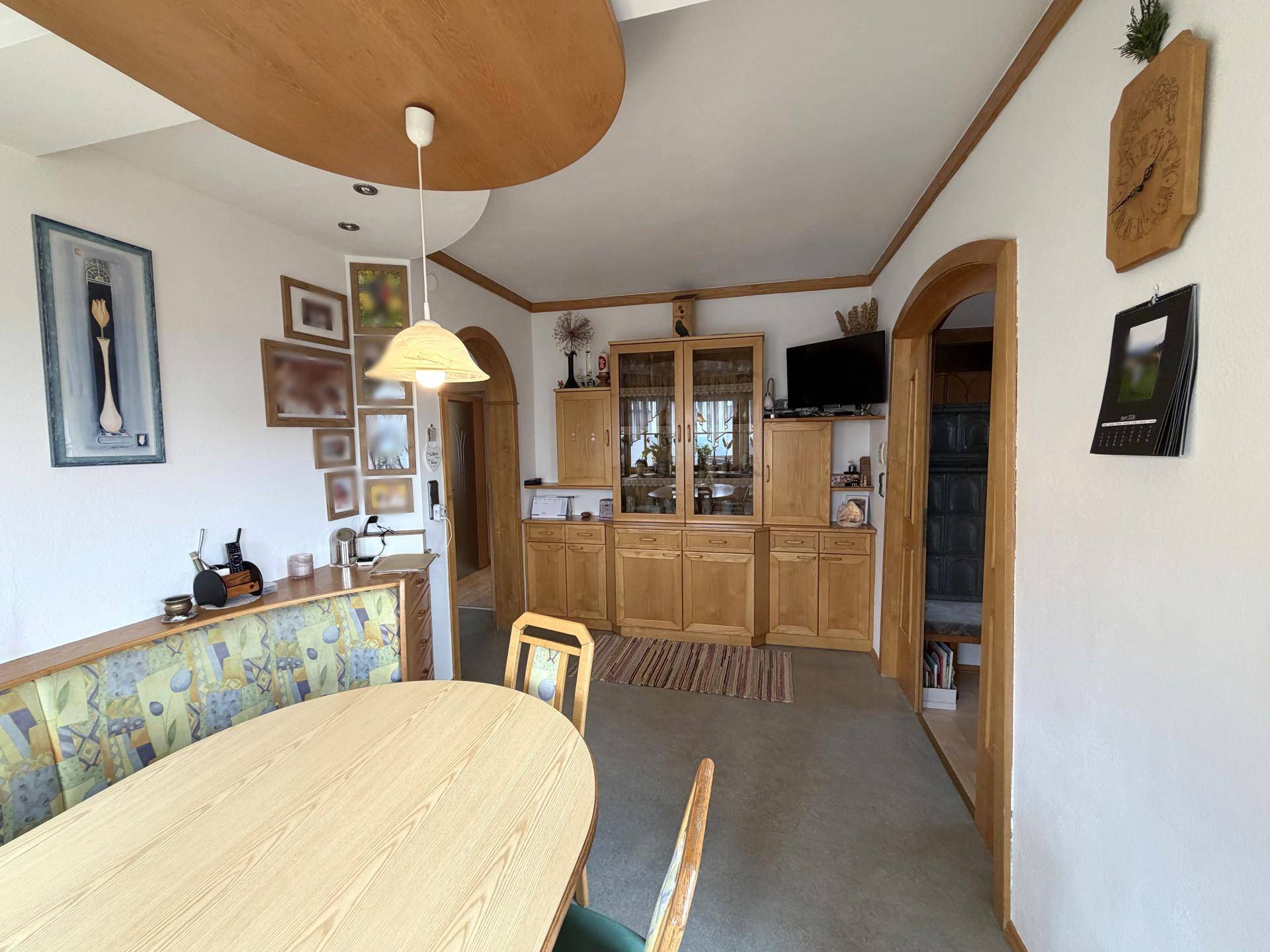 Essbereich mit Holztisch, Eckbank und passenden Schränken in traditionellem Stil.