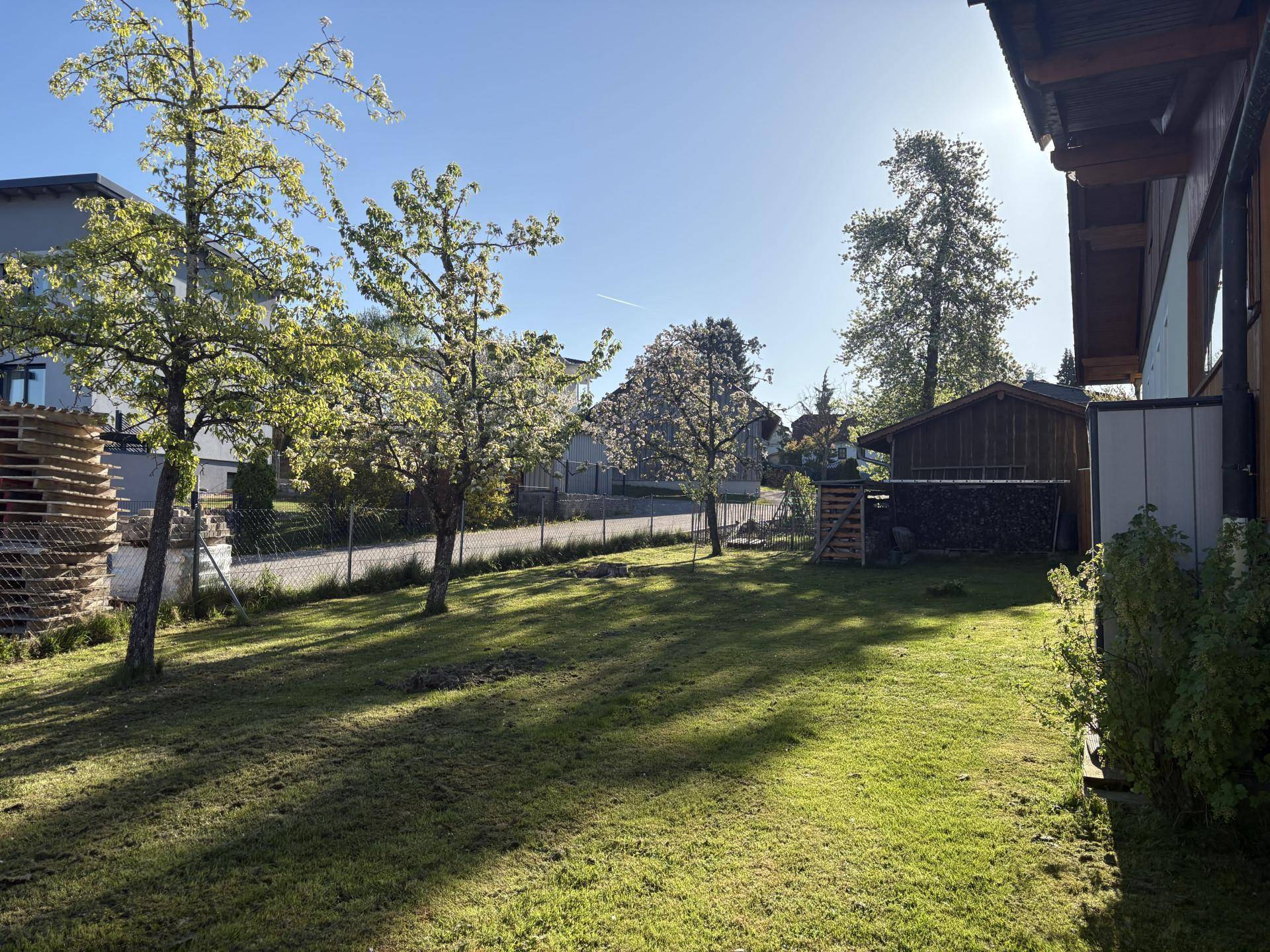 Weitläufiger Garten mit Rasenfläche, Obstbäumen und Blick auf die Umgebung.