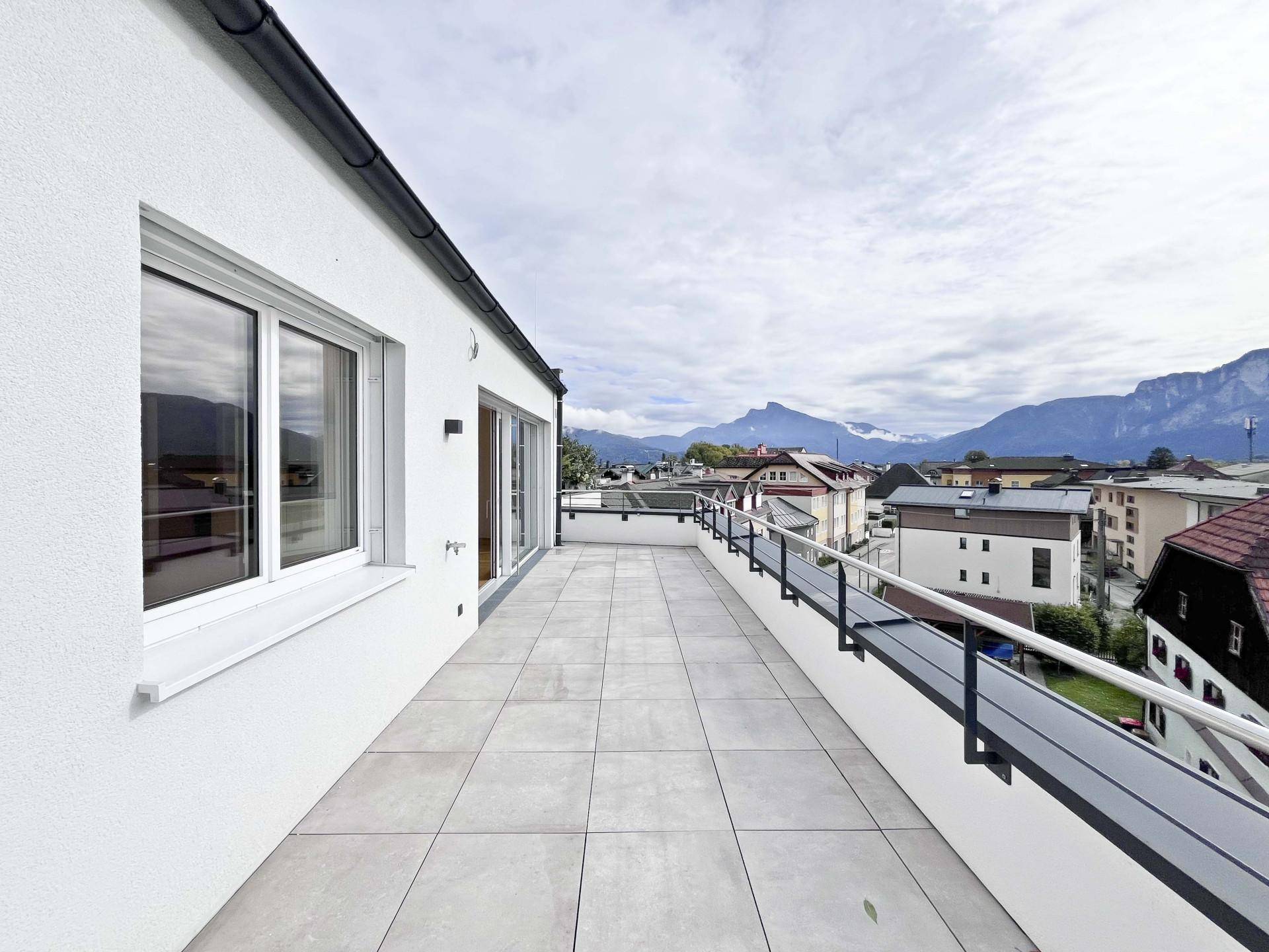 Große Dachterrasse mit Fliesenboden und weitem Blick auf die umliegende Berglandschaft.