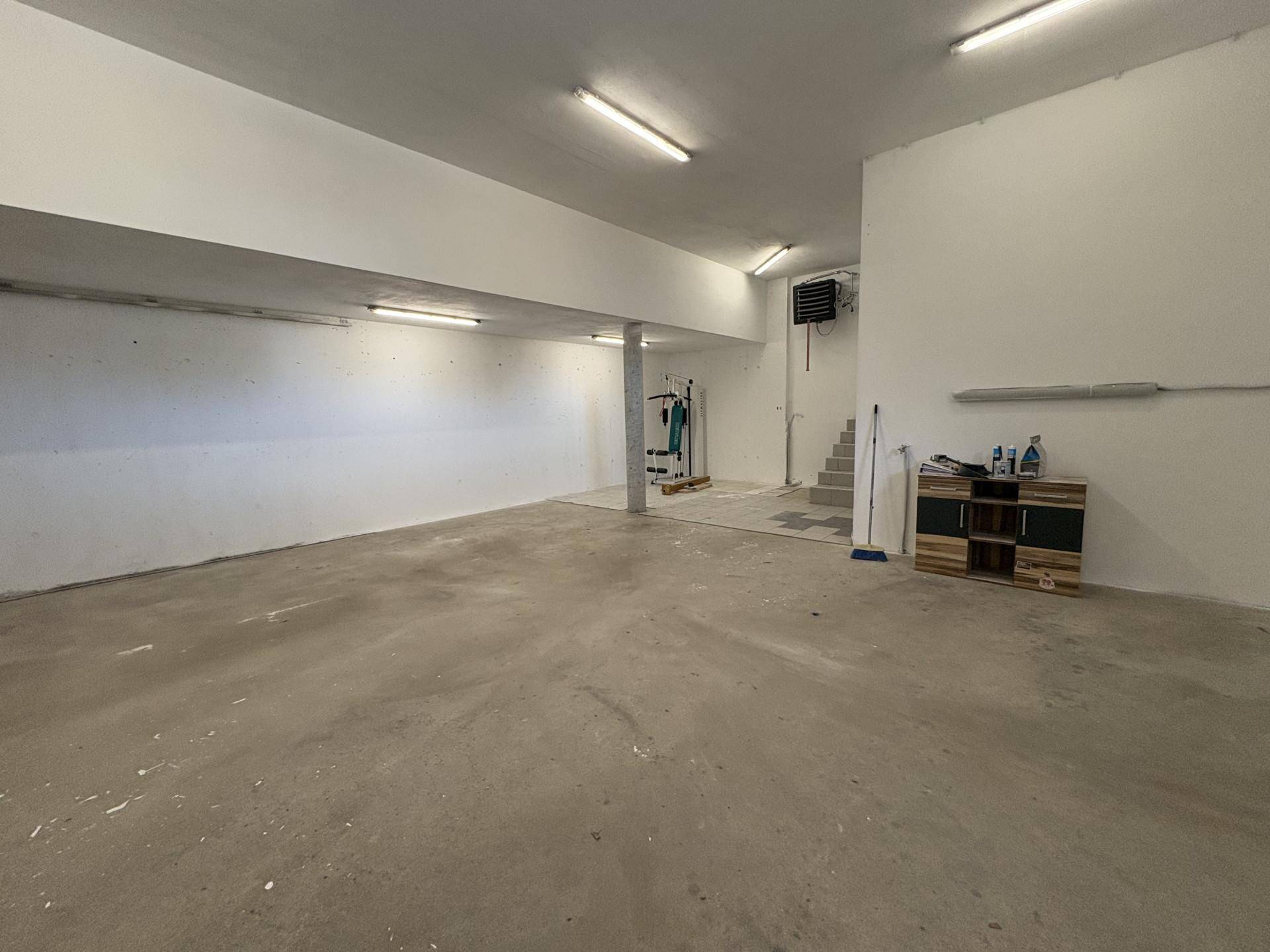 Großer Kellerraum mit Betonboden, viel Platz und einfacher Beleuchtung.