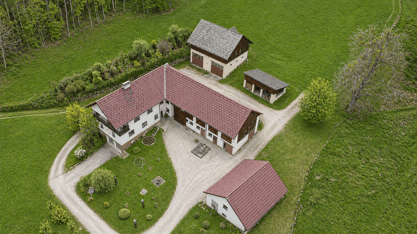 Luftaufnahme eines weitläufigen Anwesens mit mehreren Gebäuden und großem Grundstück in ländlicher Umgebung.