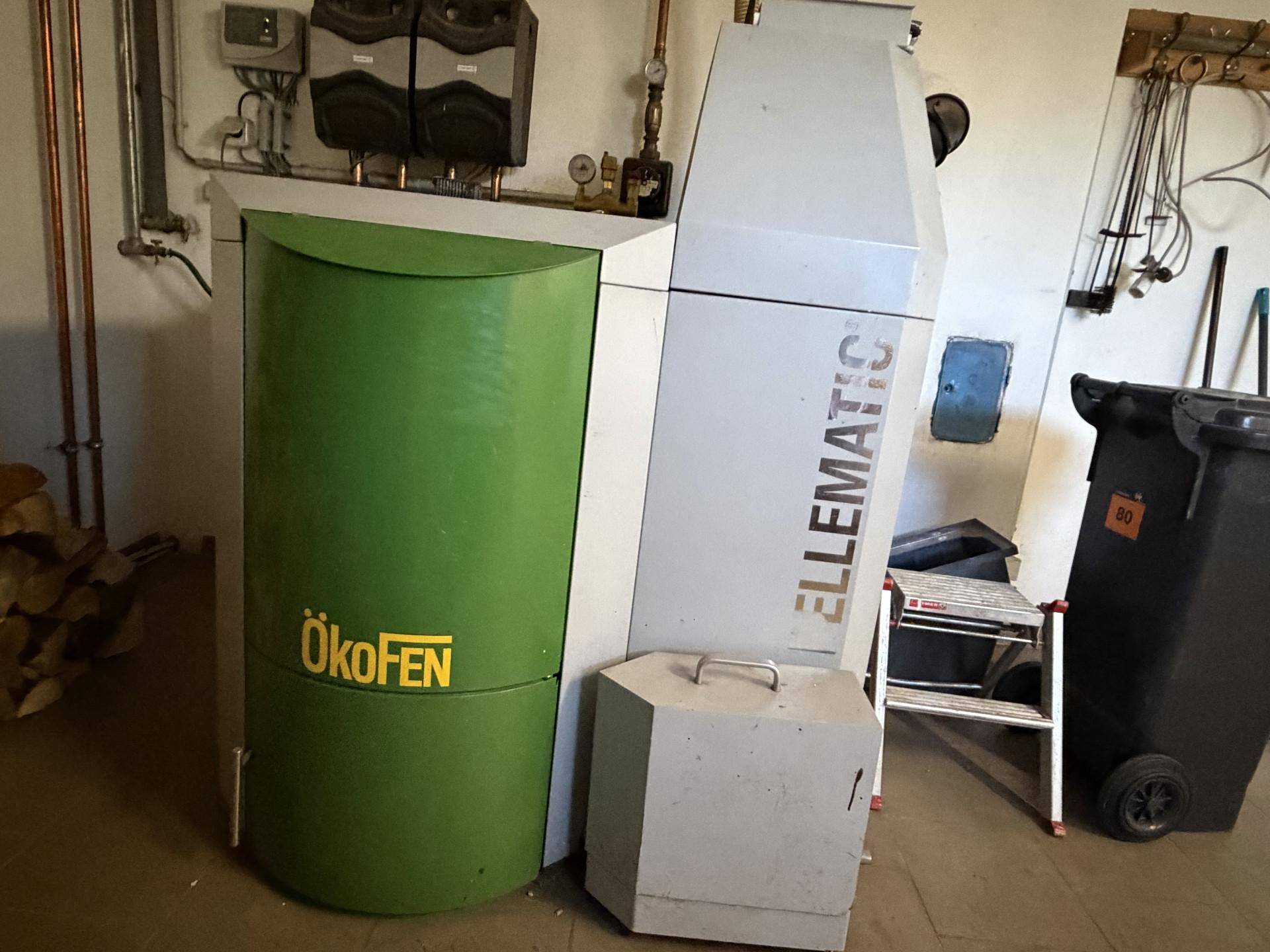 Detailansicht der Pelletheizungsanlage im Kellerraum mit Rohren und Technik.