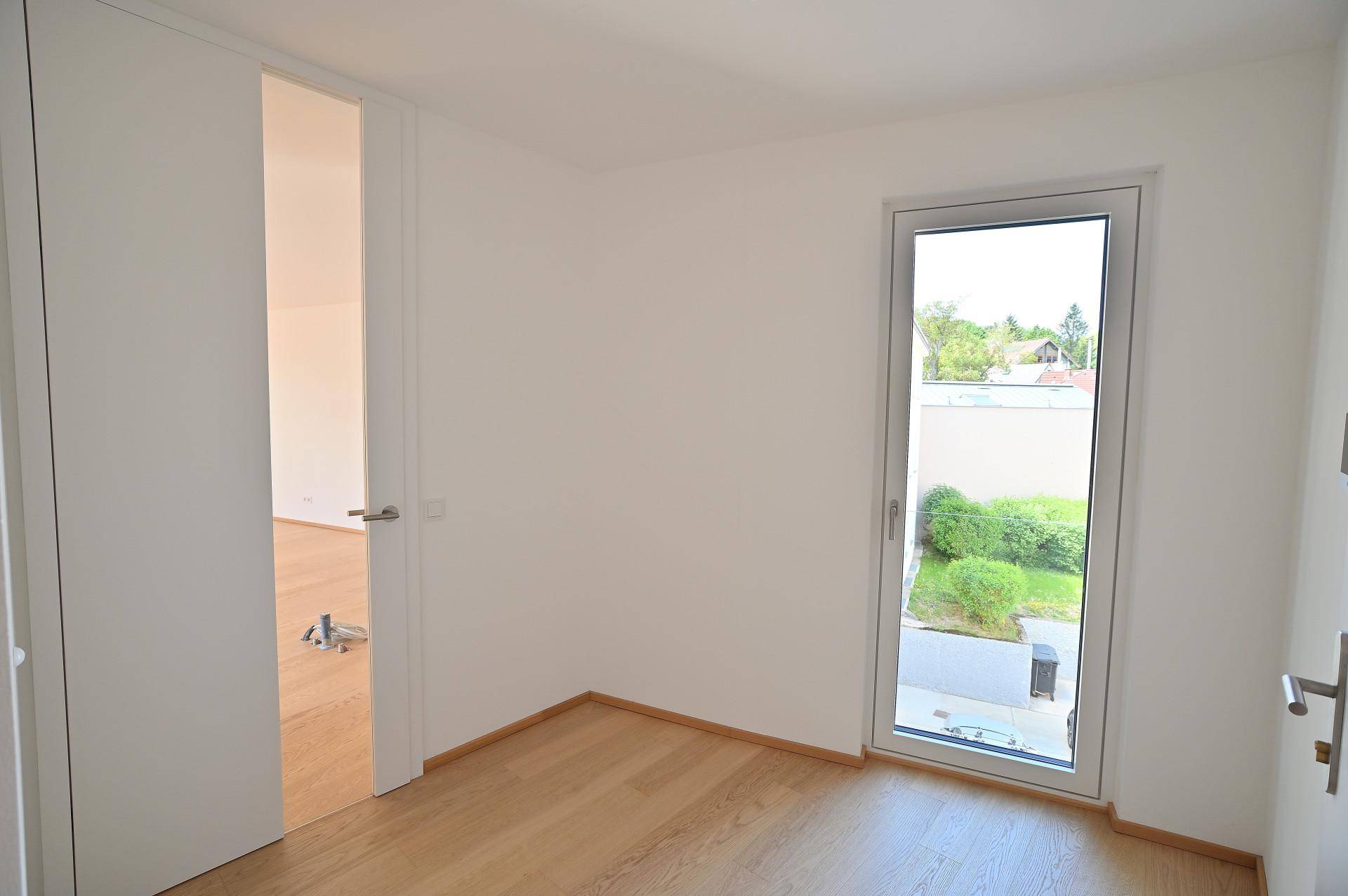 Heller Raum mit Holzboden und Fenster, der vielseitig genutzt werden kann.